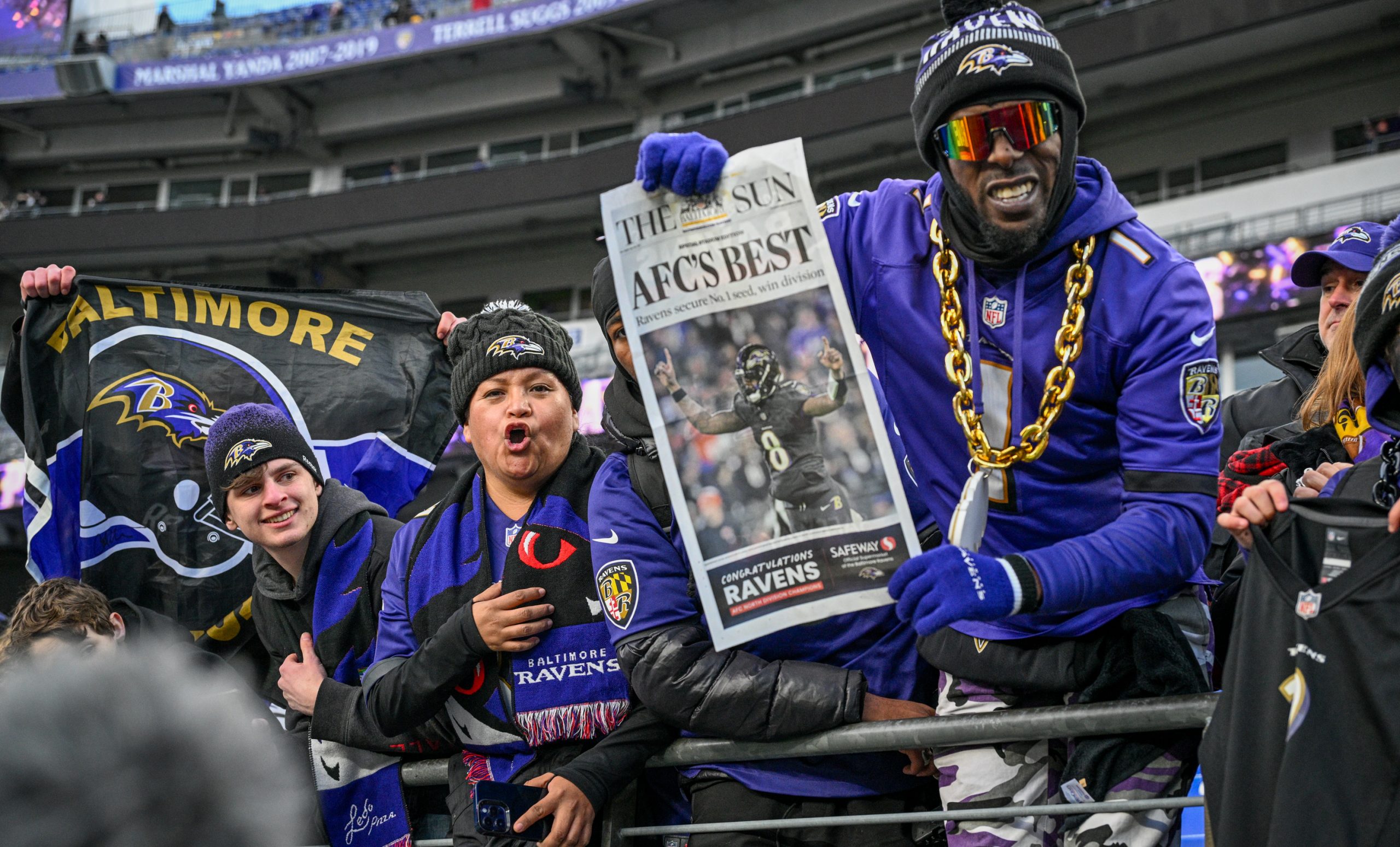 Ravens fan Keon Fisher holds up a stadium edition of...