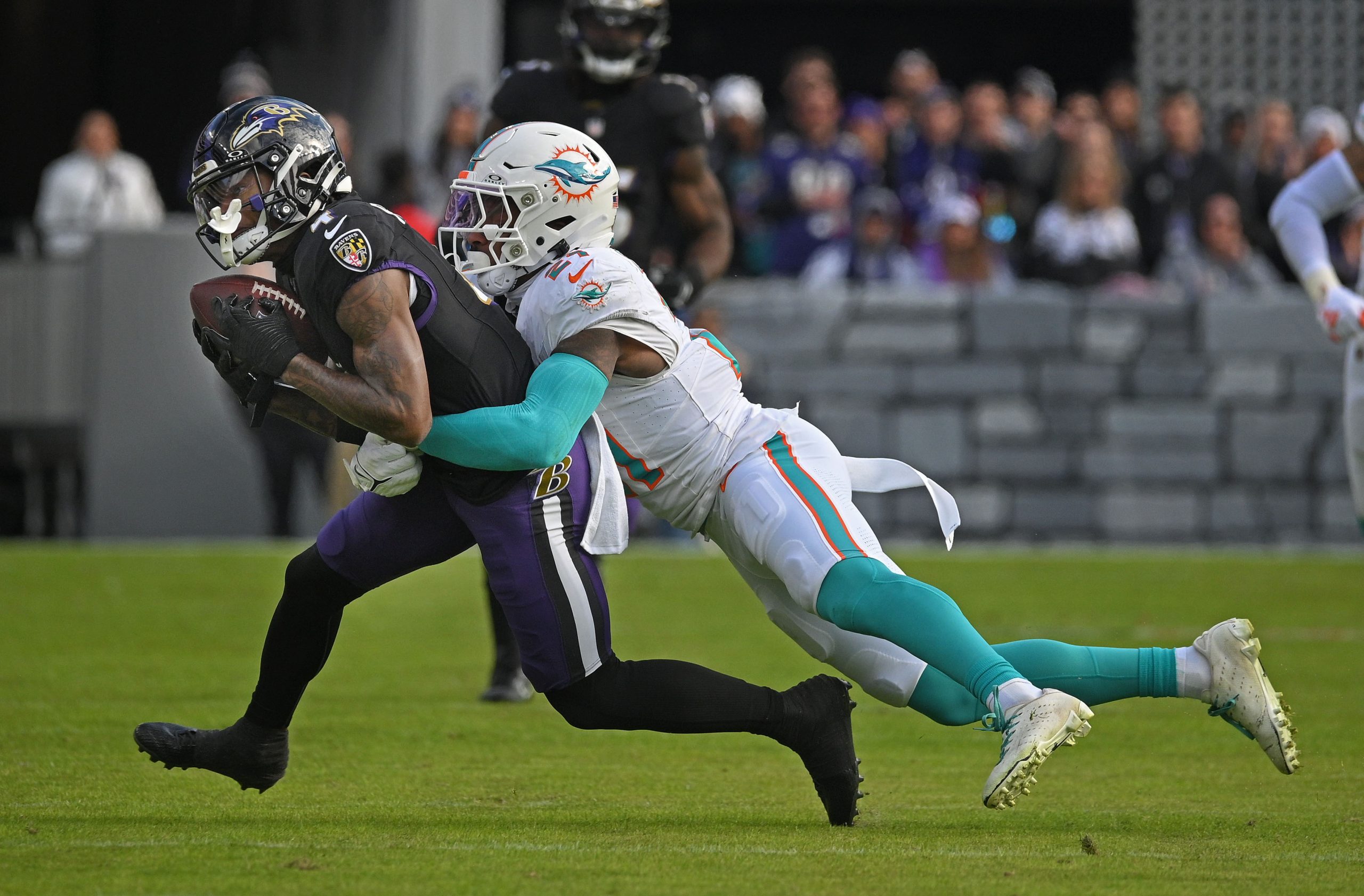 Ravens wide receiver Zay Flowers, left, catches a 25-yards pass...