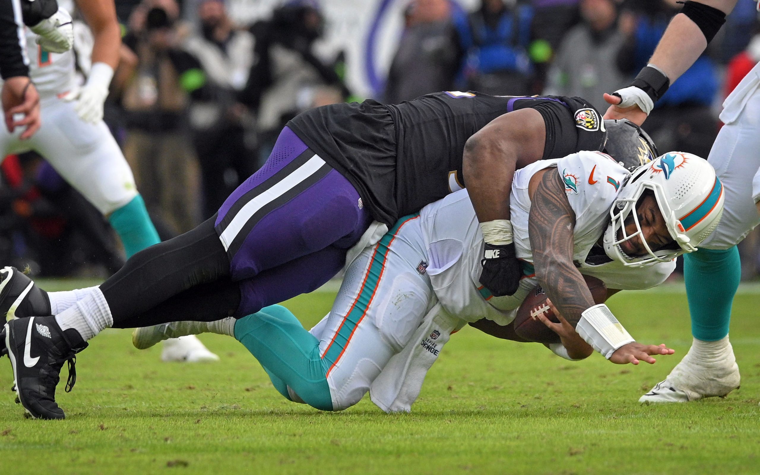 Ravensxe2x80x99 Justin Madubuike , top, sacks Dolphins quarterback Tua Tagovailoa...