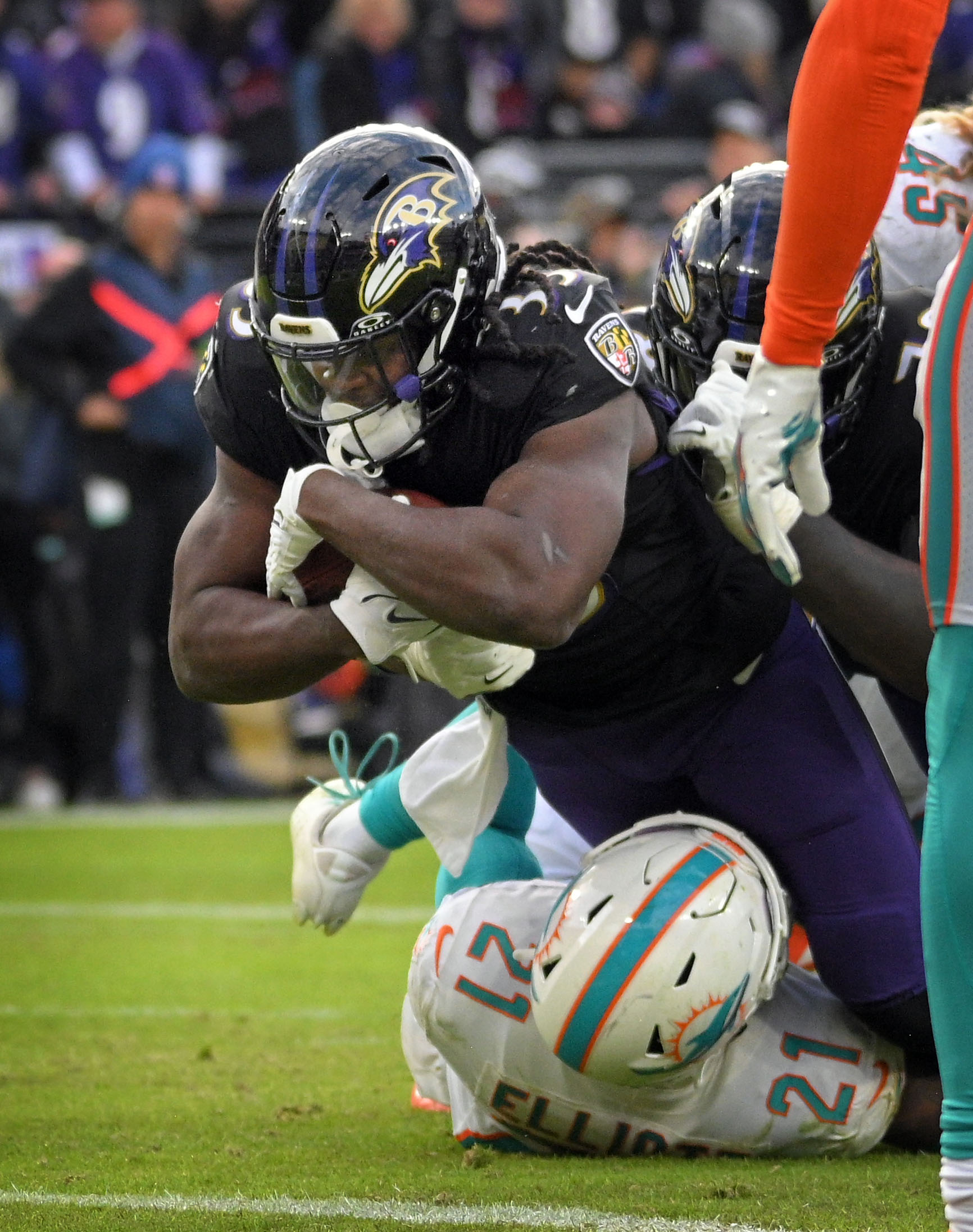 Ravens Melvin Gordon III, top, dives into the end zone...