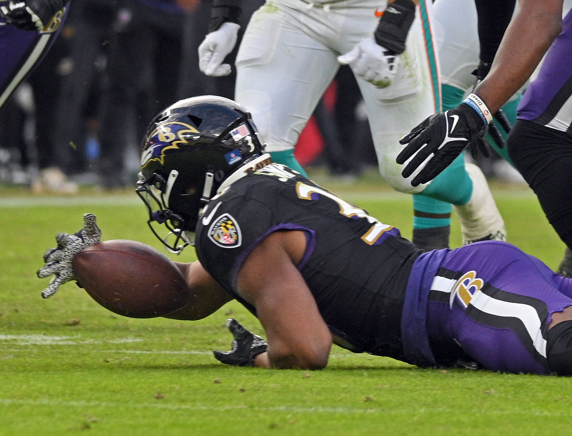 Ravensxe2x80x99 Trenton Simpson picks up a Dolphins fumble in the...