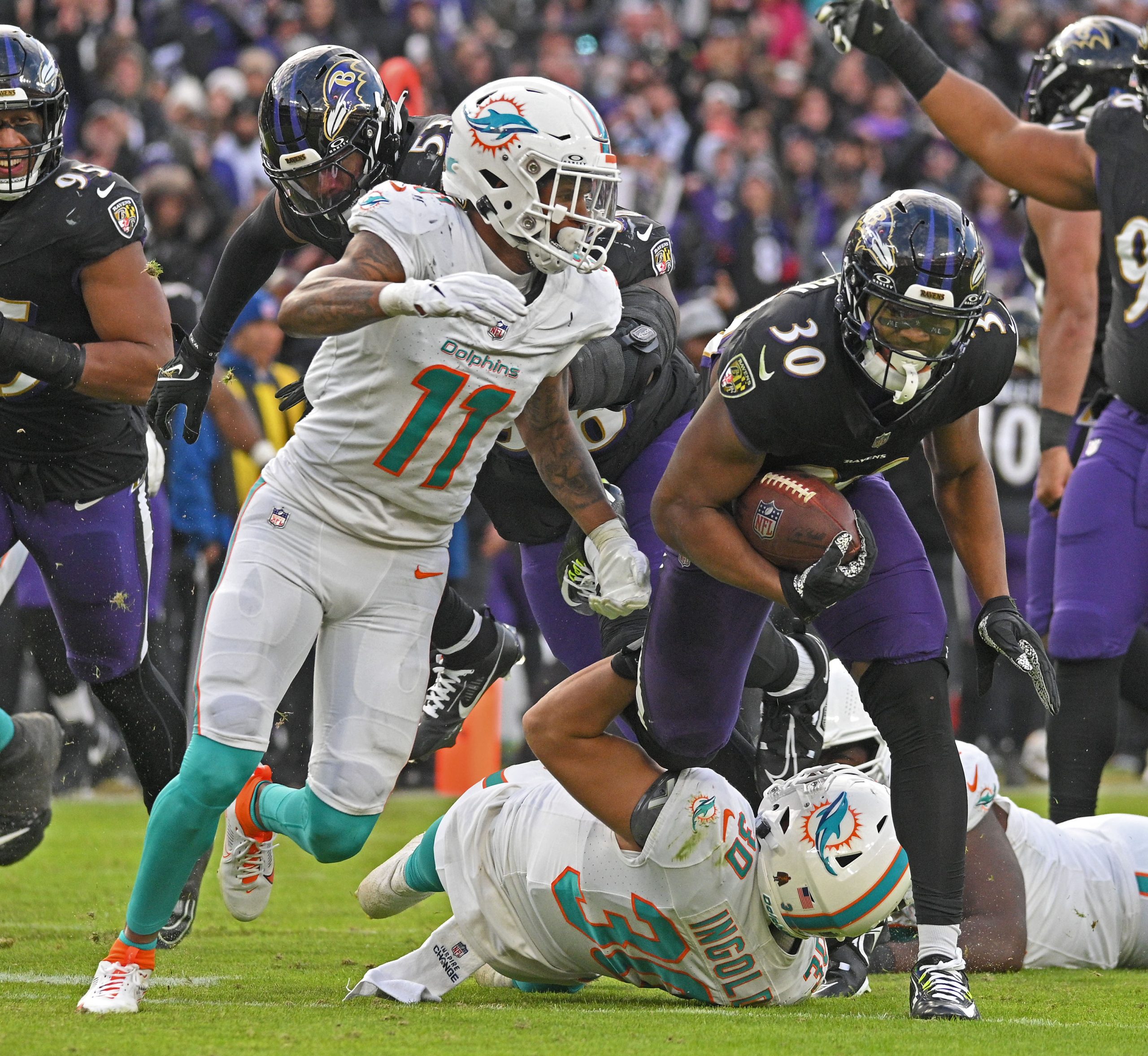 Ravensxe2x80x99 Trenton Simpson, right, runs back a Dolphins fumble in...