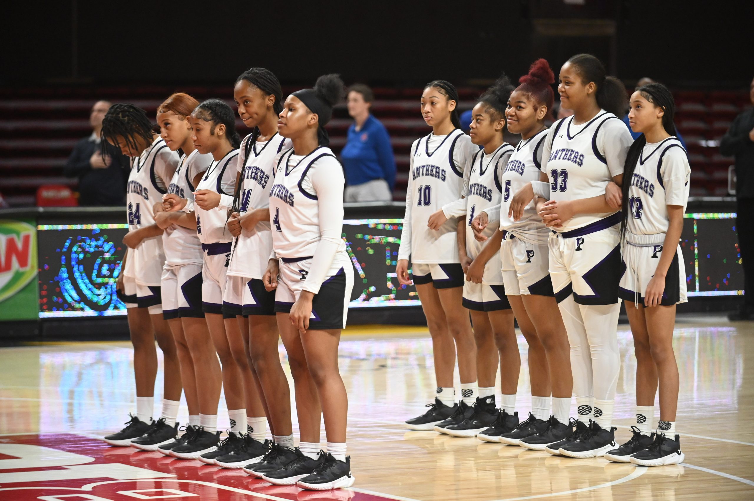 Pikesville players pause for the national anthem before their match...