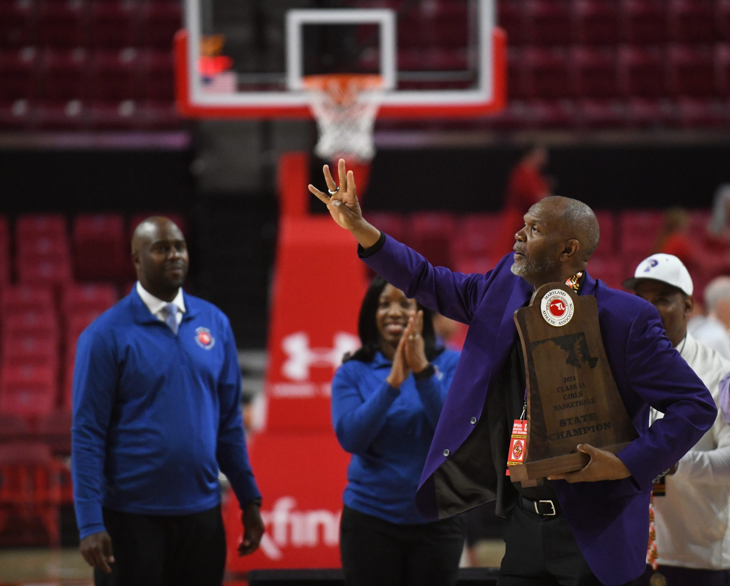 Pikesville head coach Michael Dukes raises four fingers to celebrate...