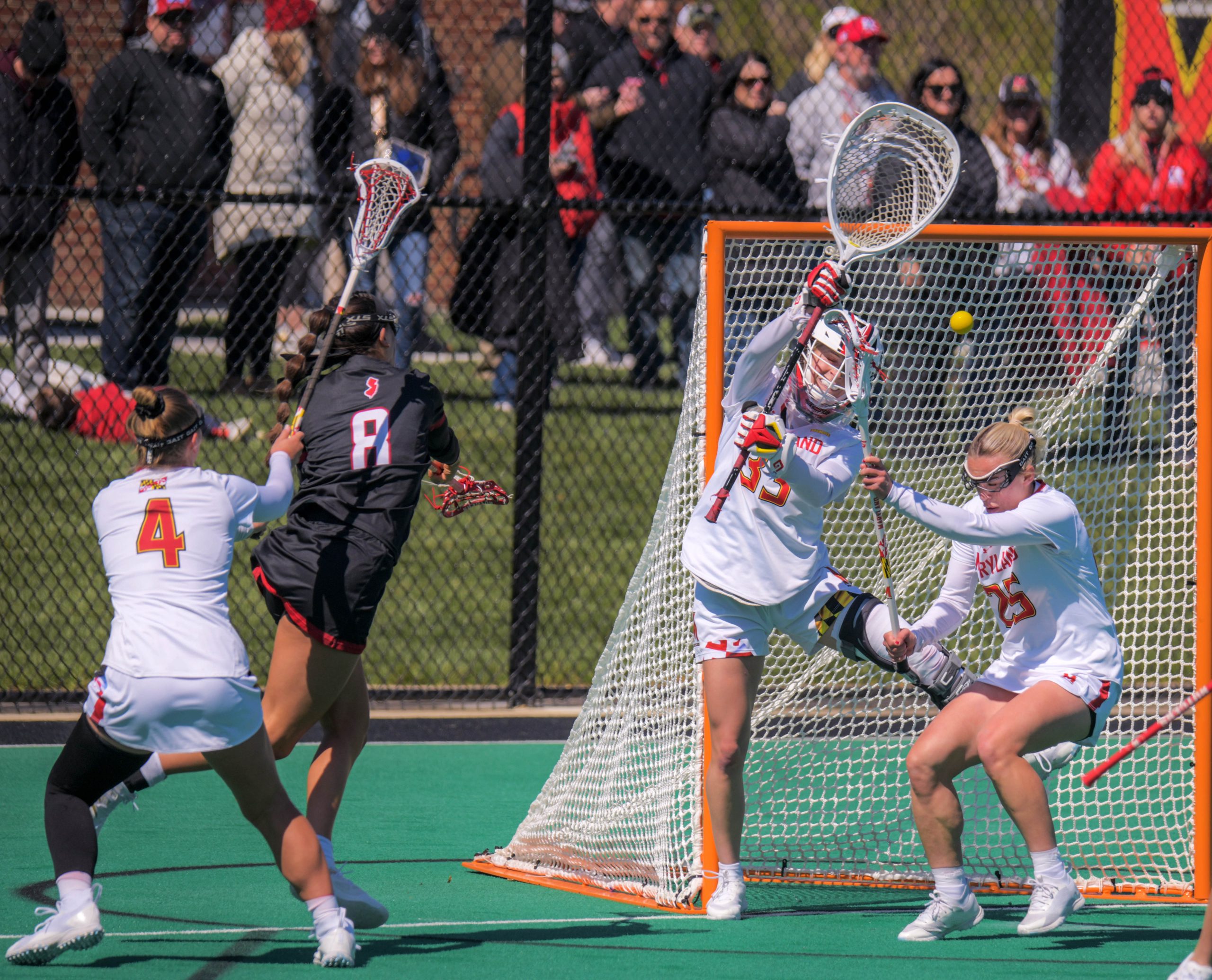 Maryland Terrapins defender Sophie Halus assists goalkeeper Emily Sterling who...