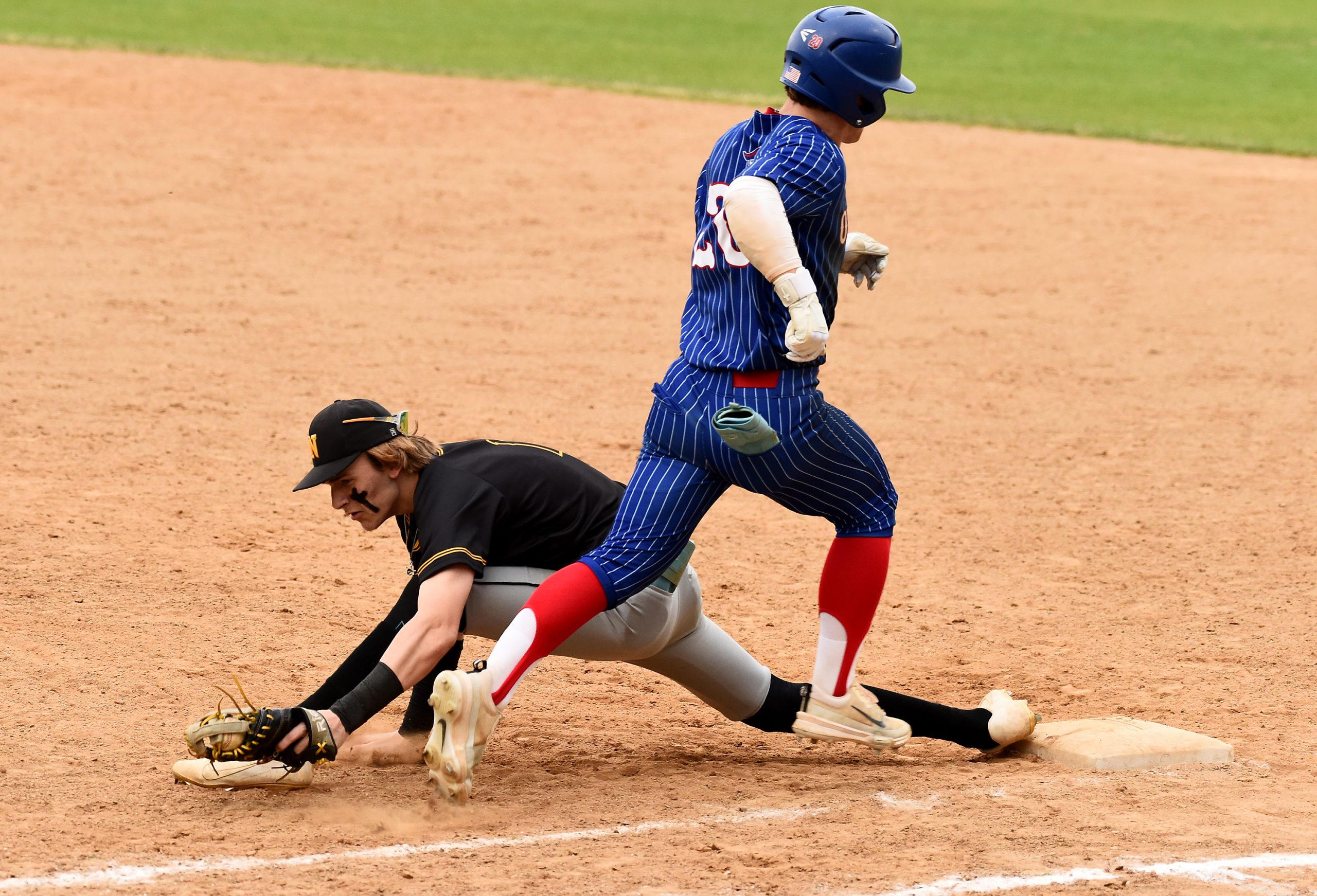 Northeast first baseman Landon Shriver keeps his foot on the...