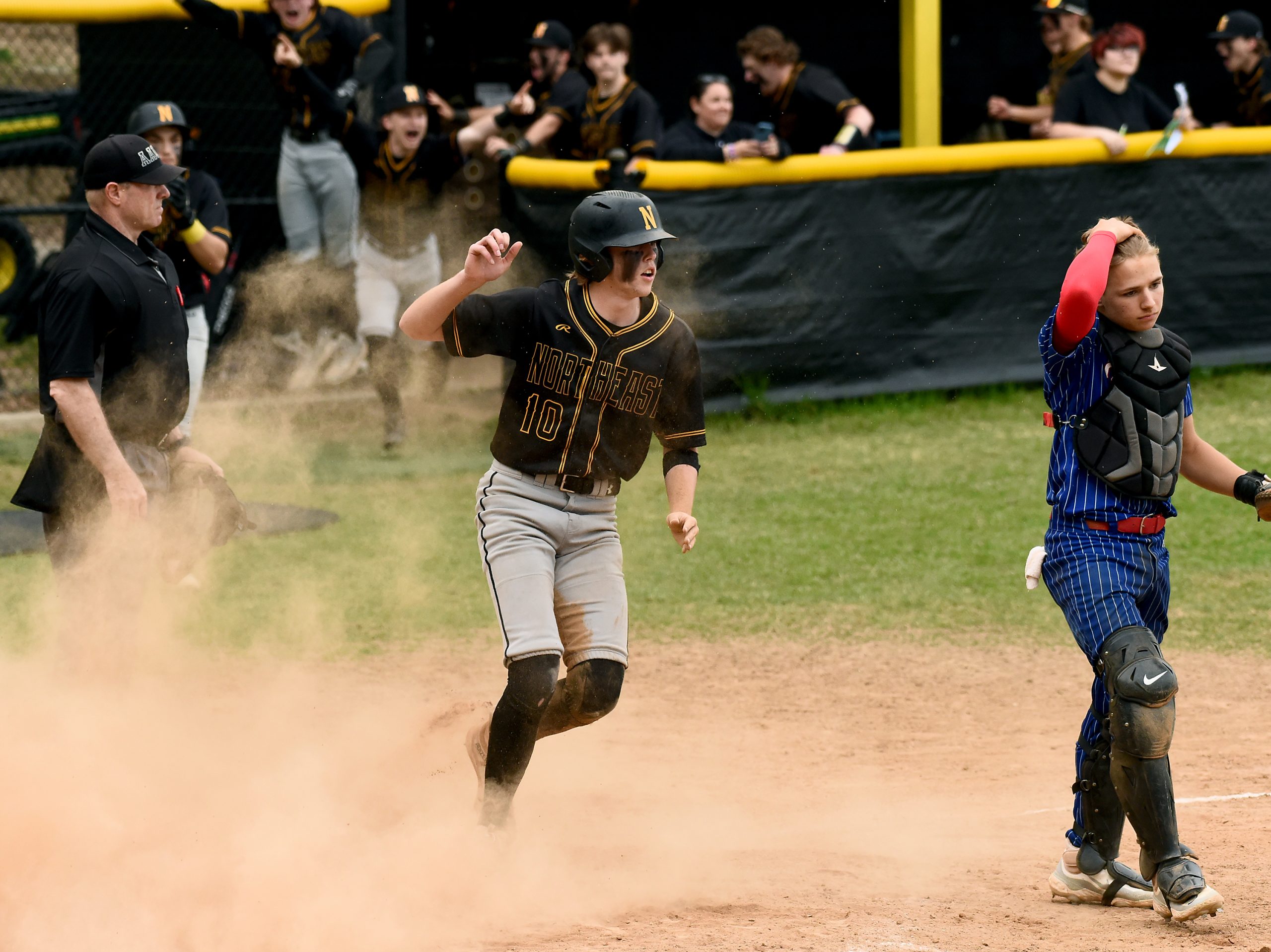 Northeast’s Jackson Palmer celebrates scoring the winning run on Landon...