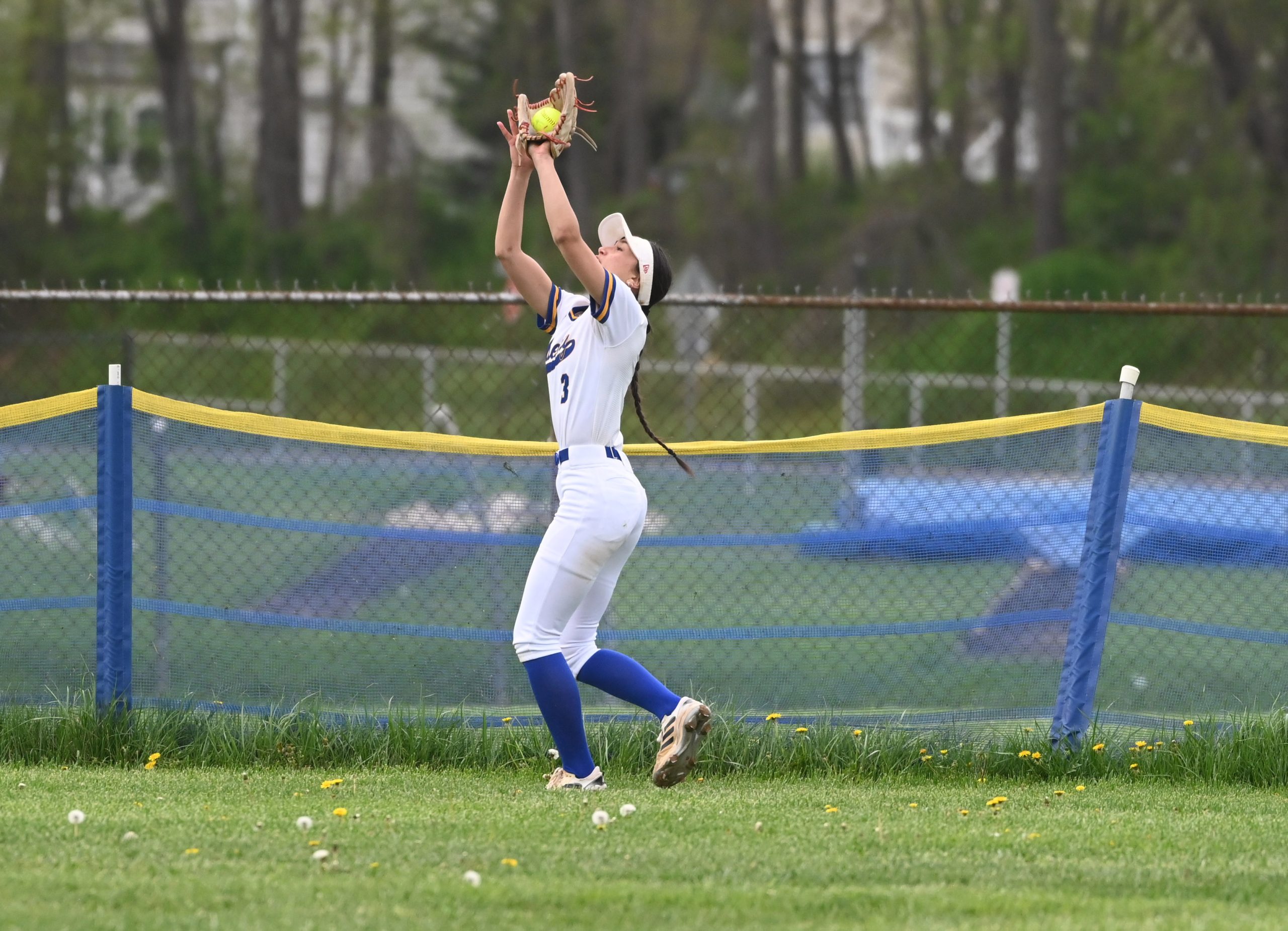 Liberty outfielder Hailey Hodges makes a catch by the fence...