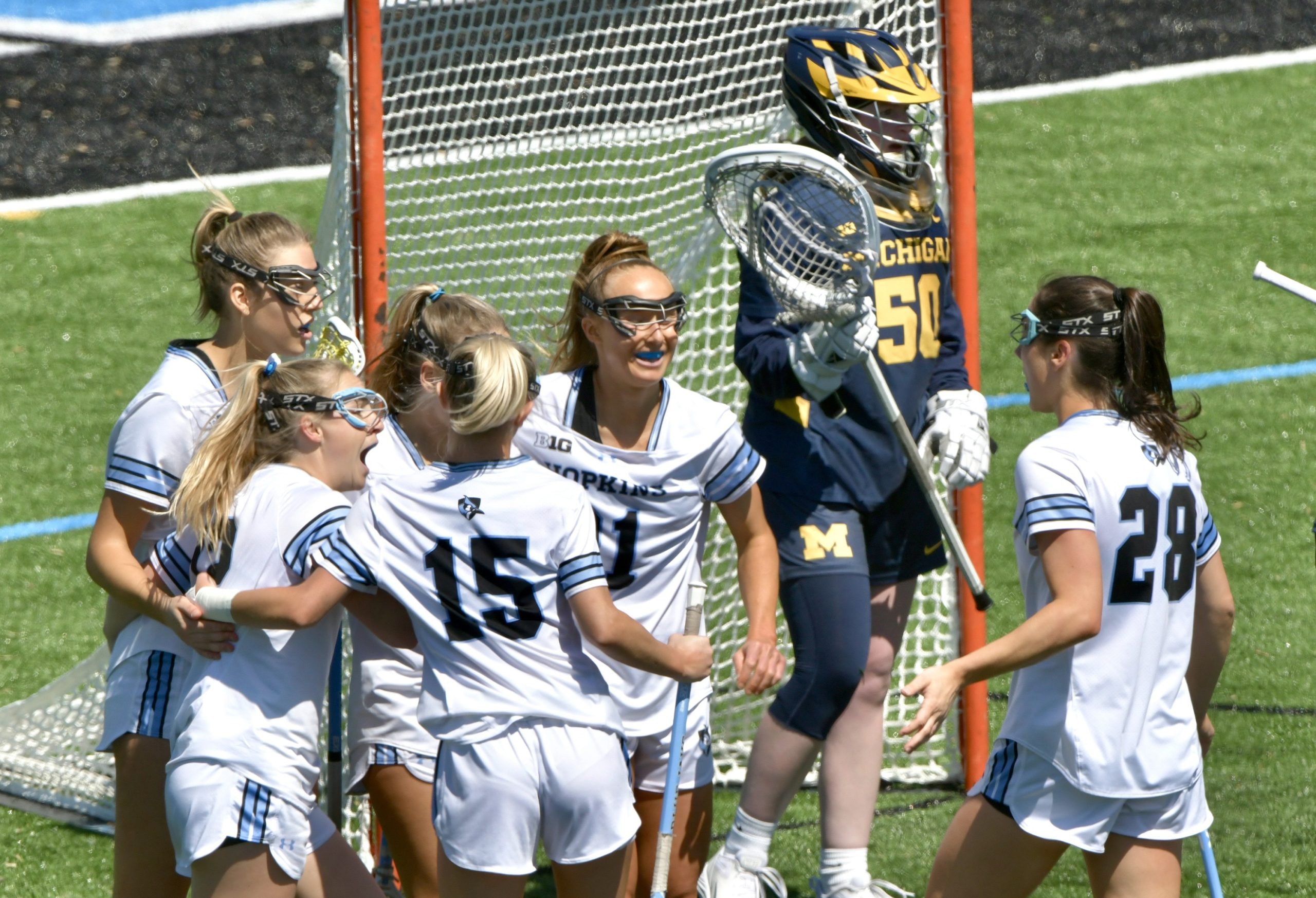 Johns Hopkins’ Bailey Cheetham #12, second from left, is congratulated...