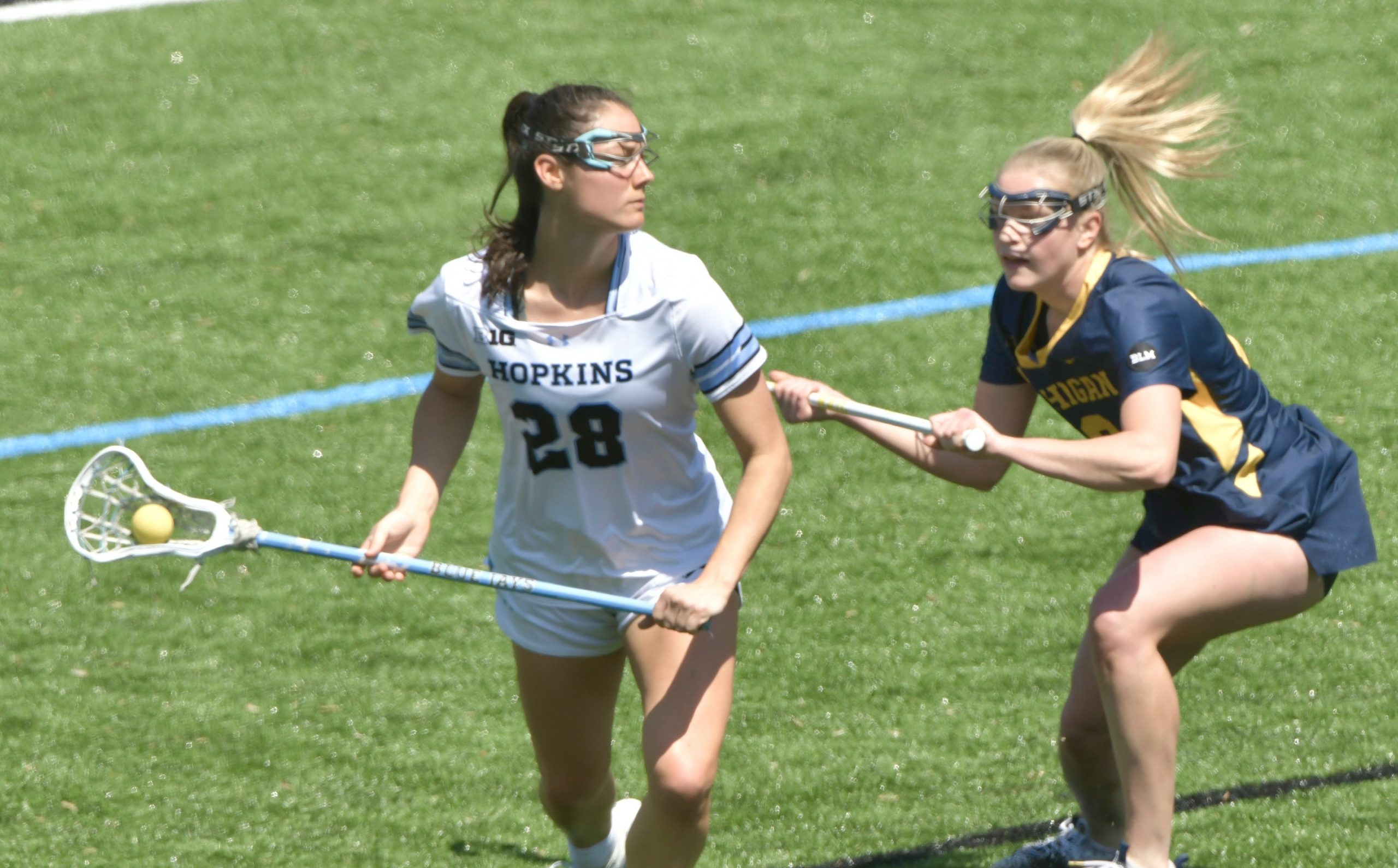 Johns Hopkins’ Abby Hurlbrink #28, left, looks for an opening...