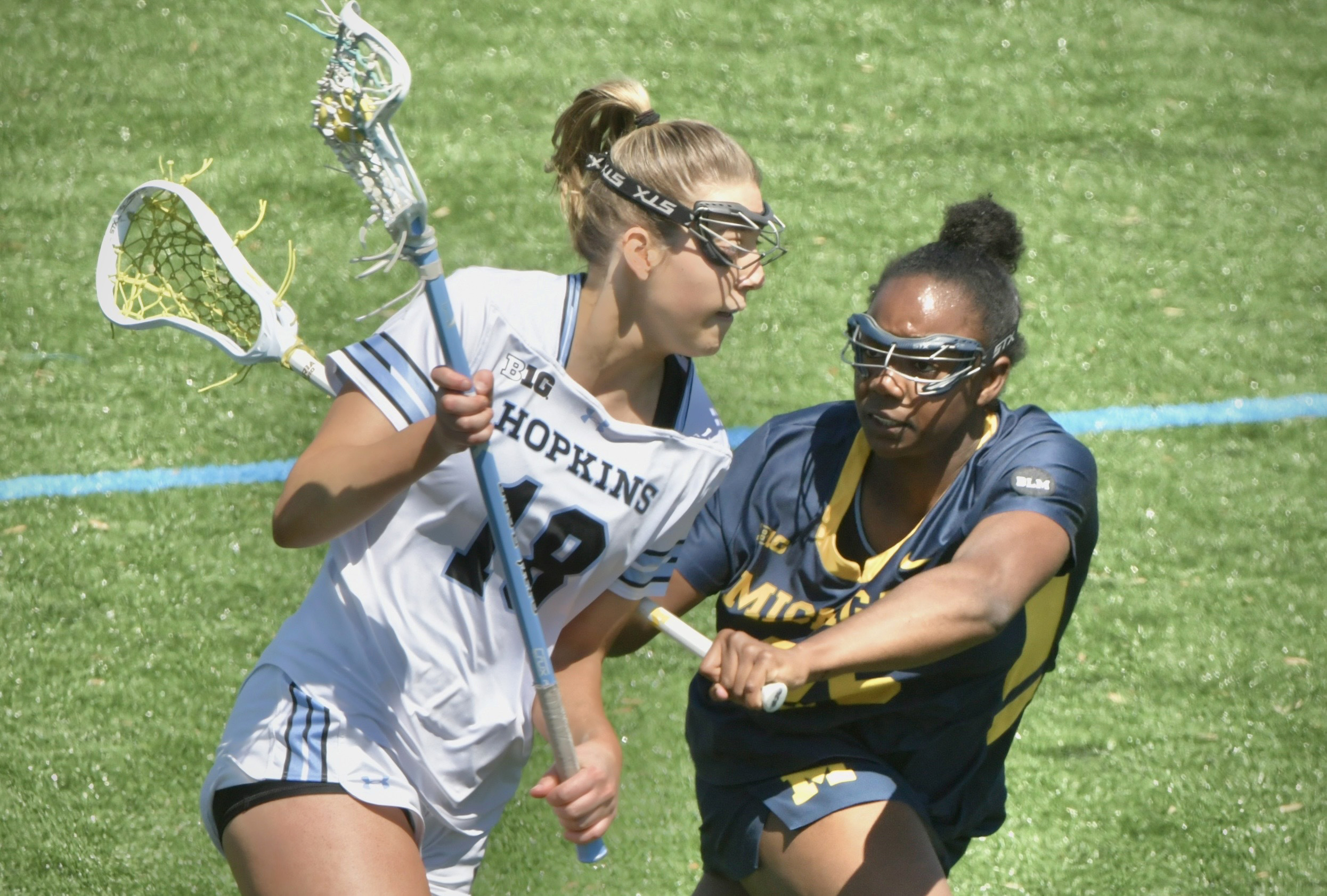 Michigan’s Jordyn Harrison #28, right, pressures Hopkins’ Ava Angello as...