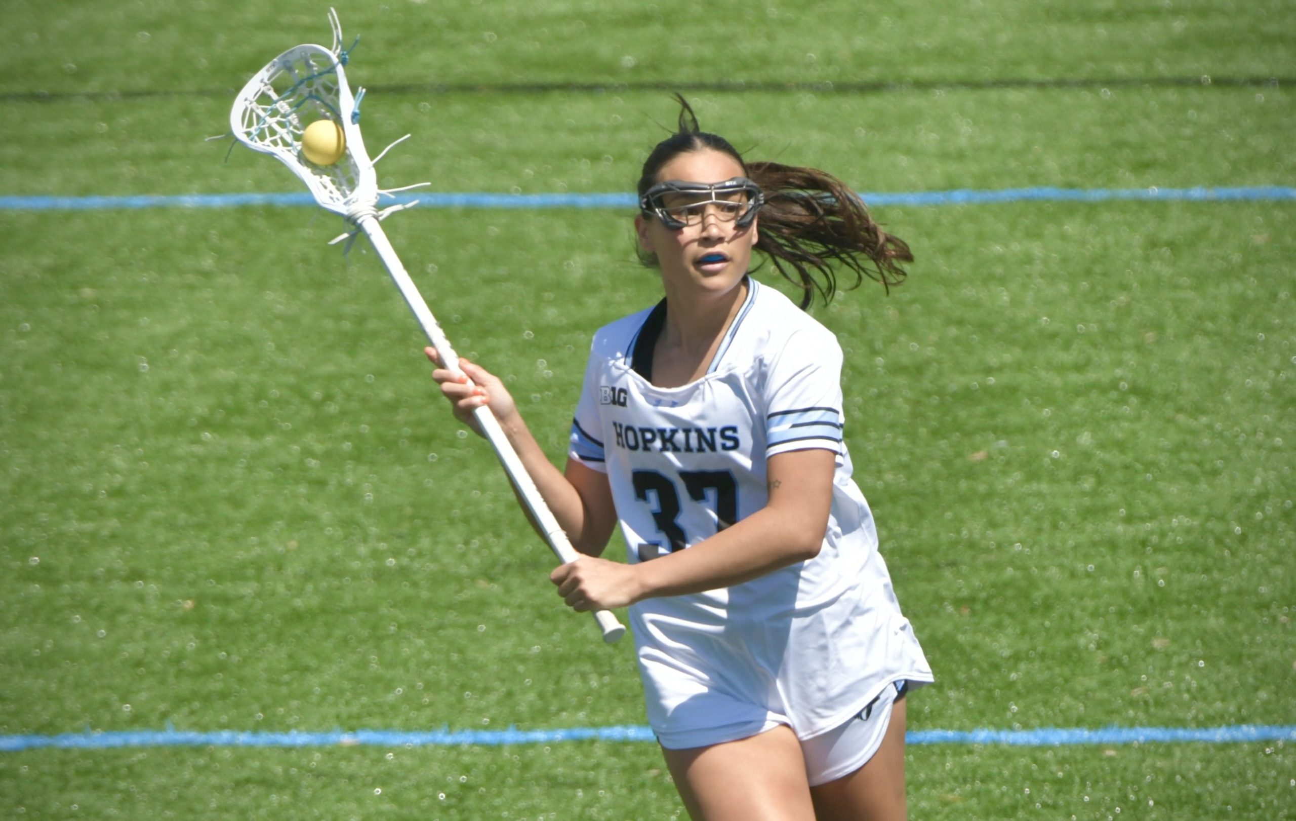 Johns Hopkins defender Kacie Riggs #37 moves the ball down...