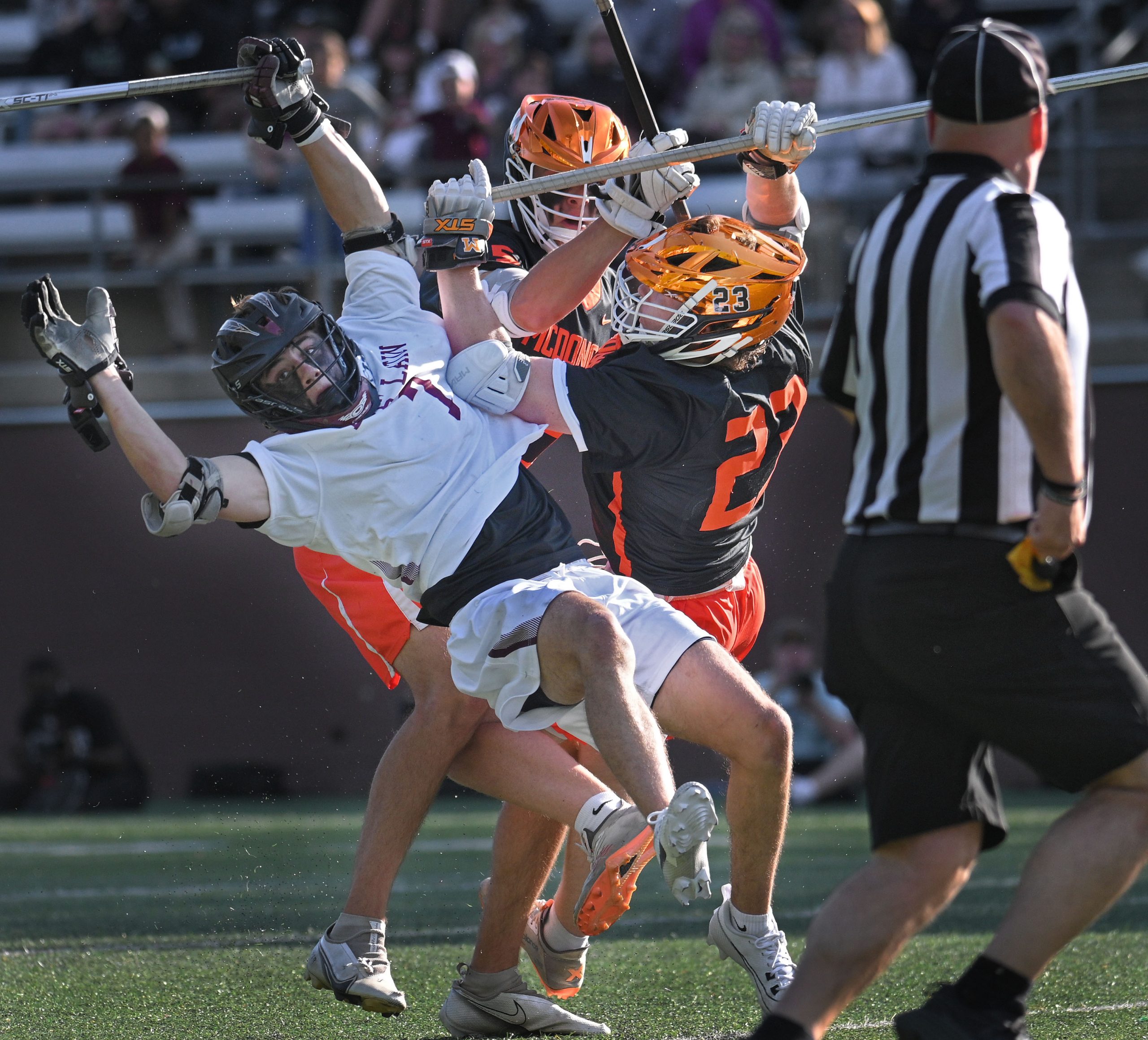 McDonogh’s Liam Whittle, center, makes an illegal cross check on...