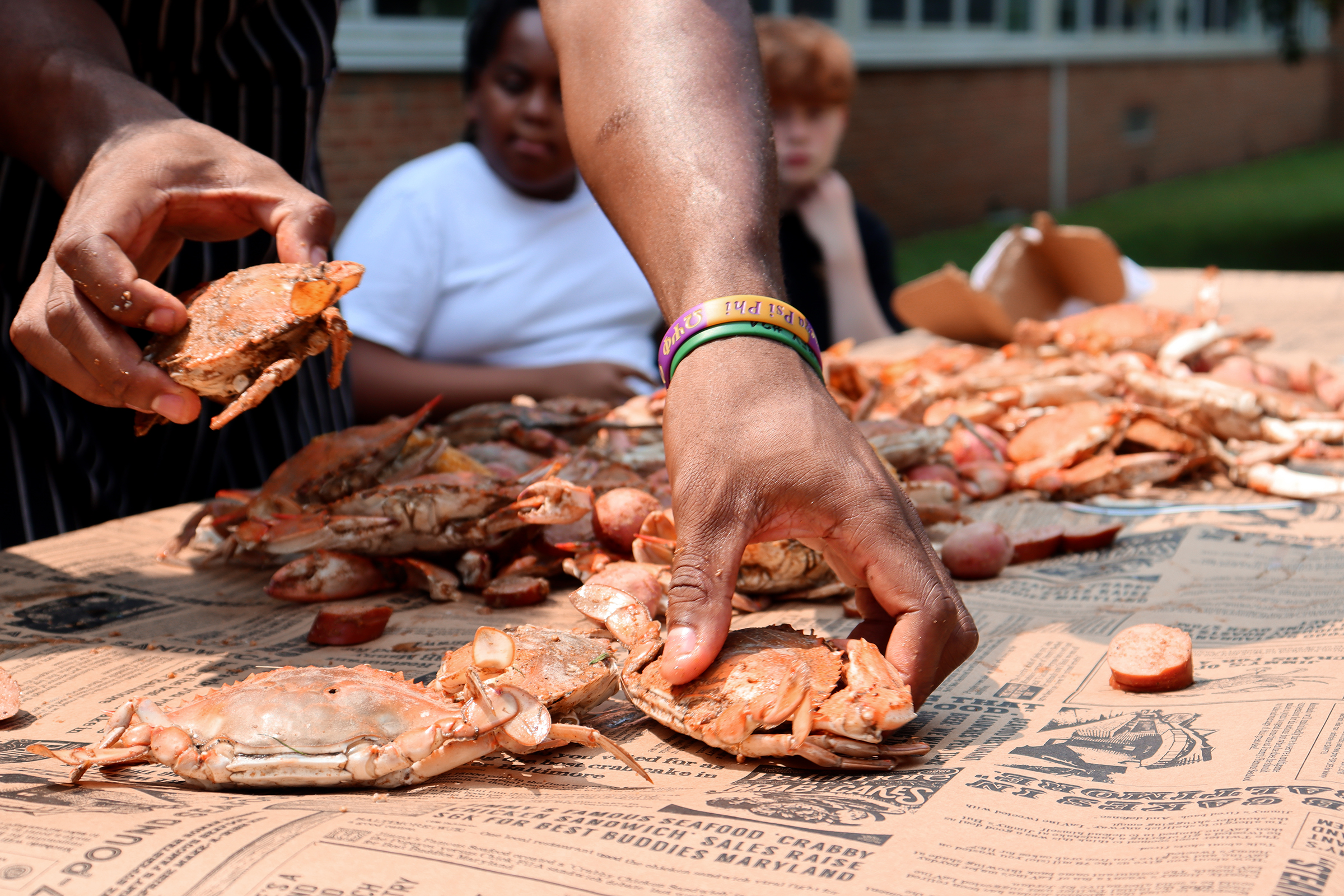 Annapolis Middle School counselor Justin Rowland lays freshly steamed crabs...