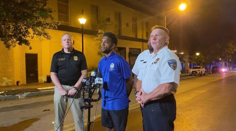 Mayor Brandon Scott, center, speaks about the Baltimore Police Department...