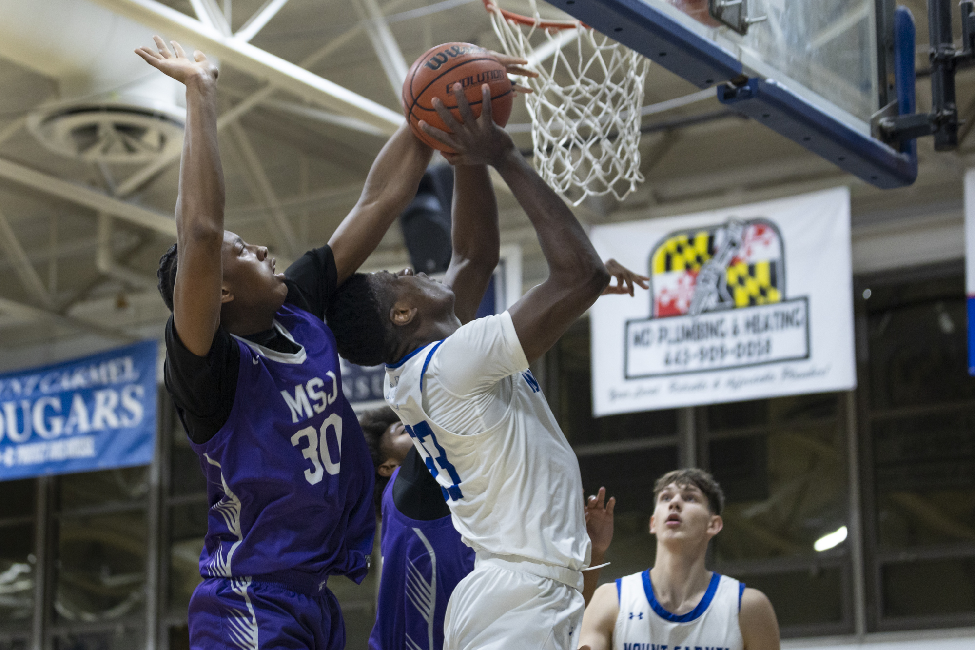 Mount Saint Joseph’s Brandon Holmes blocks the shot of Junior...