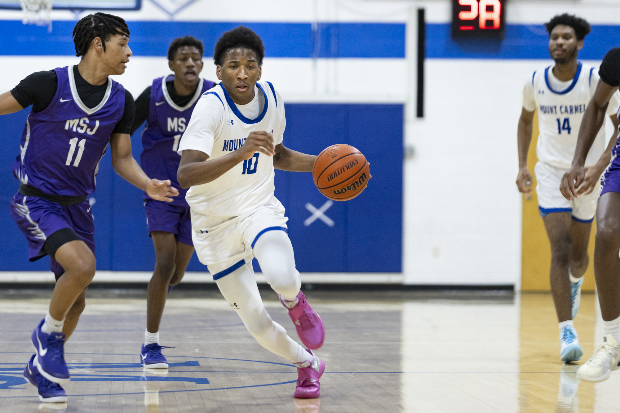 Tristen Wilson carries the ball downcourt during the game between...