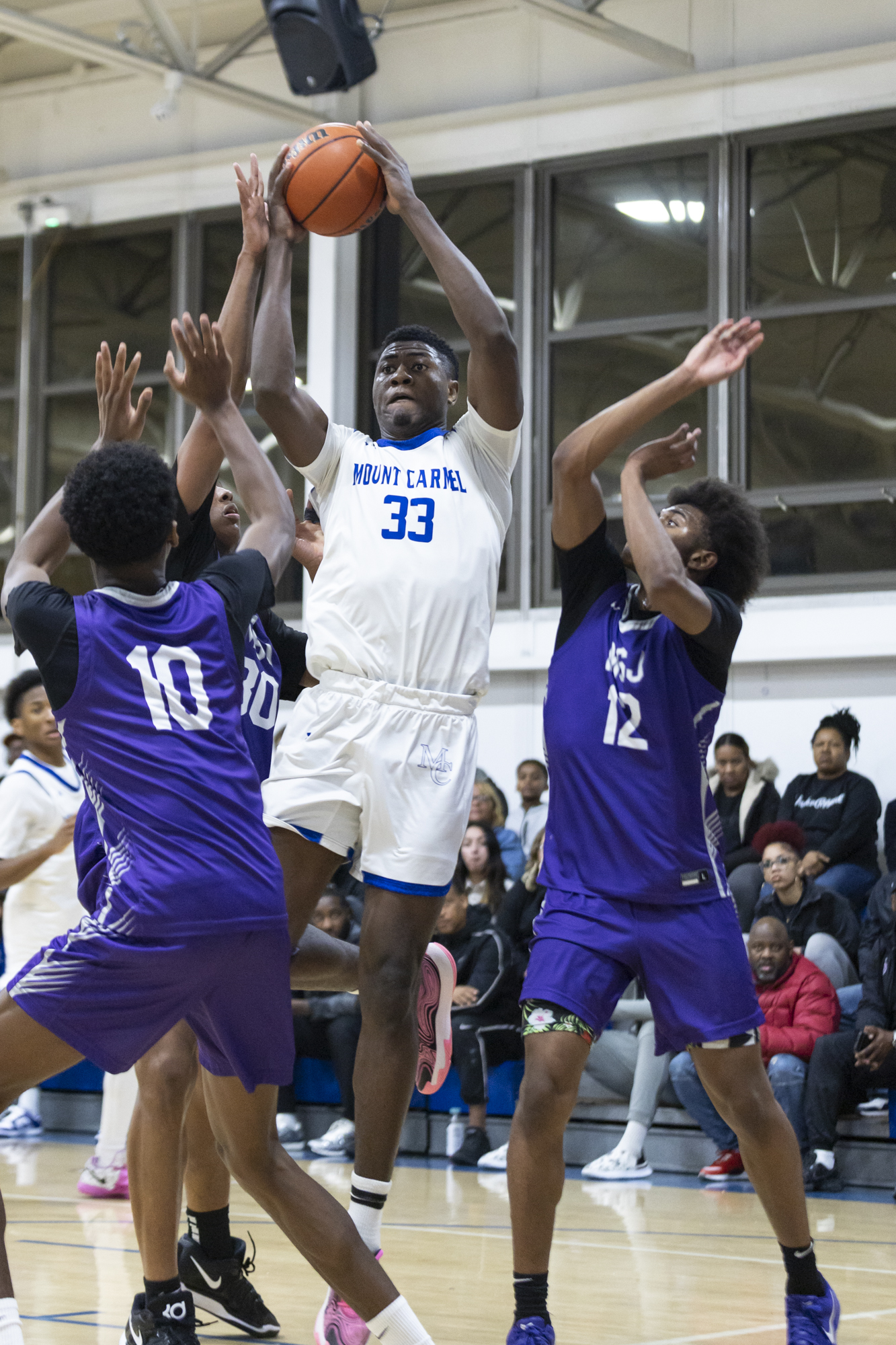 Our Lady of Mount Carmel’s Junior Mancho pulls down a...