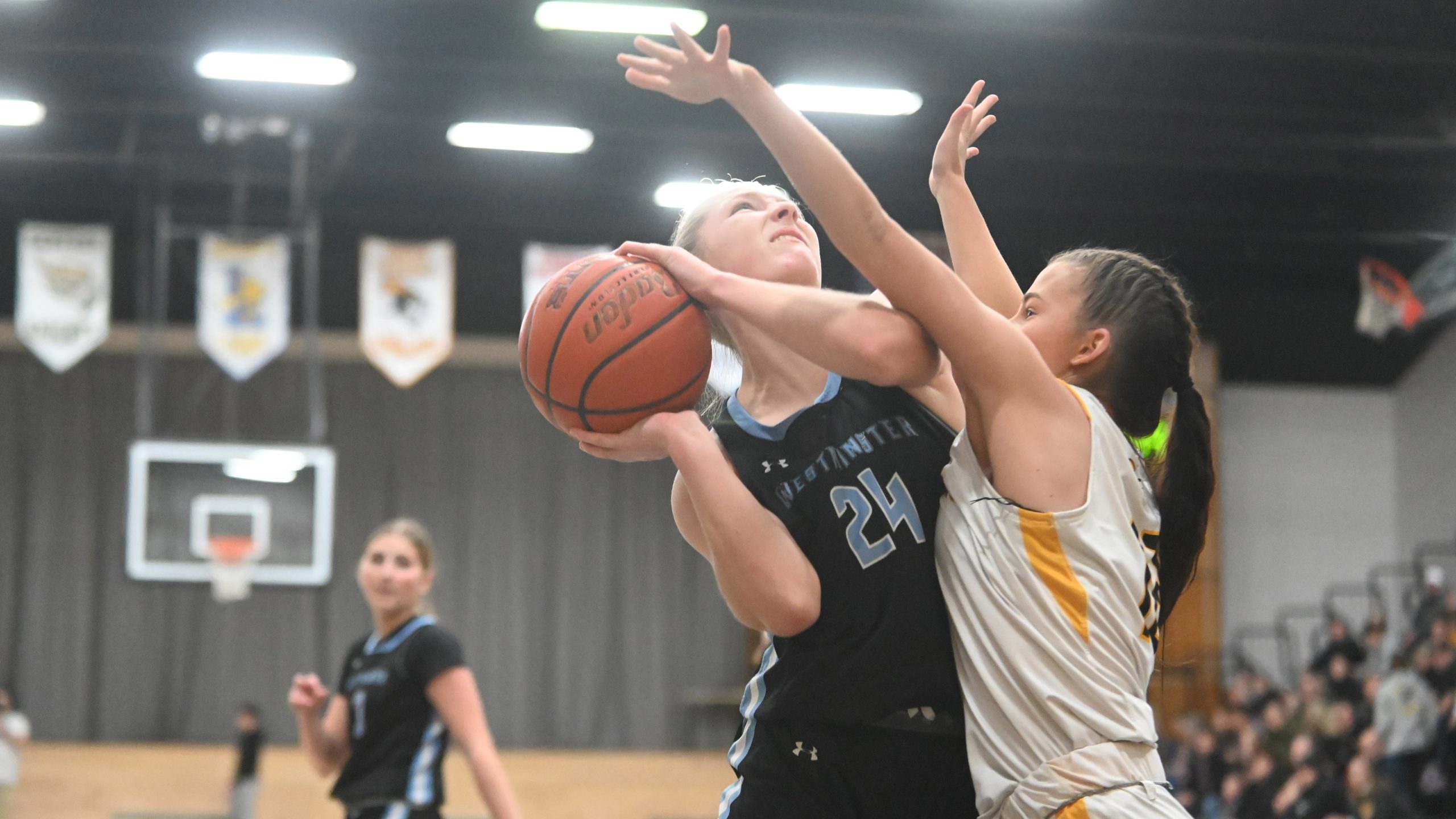 Westminster's Maddy Gassmar tries to get a shot off with...
