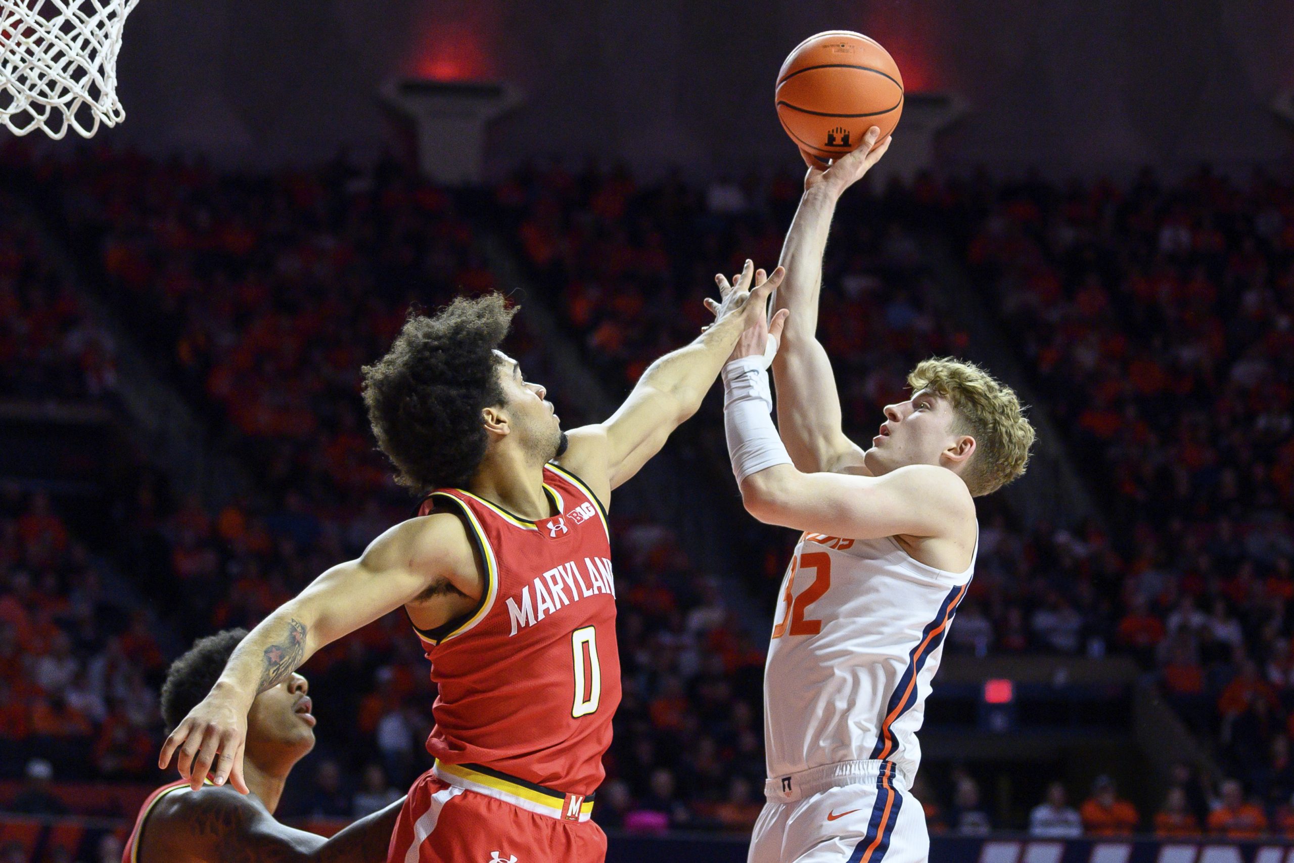 Illinois' Kasparas Jakucionis, right, looks to shoot shoots over Maryland's...