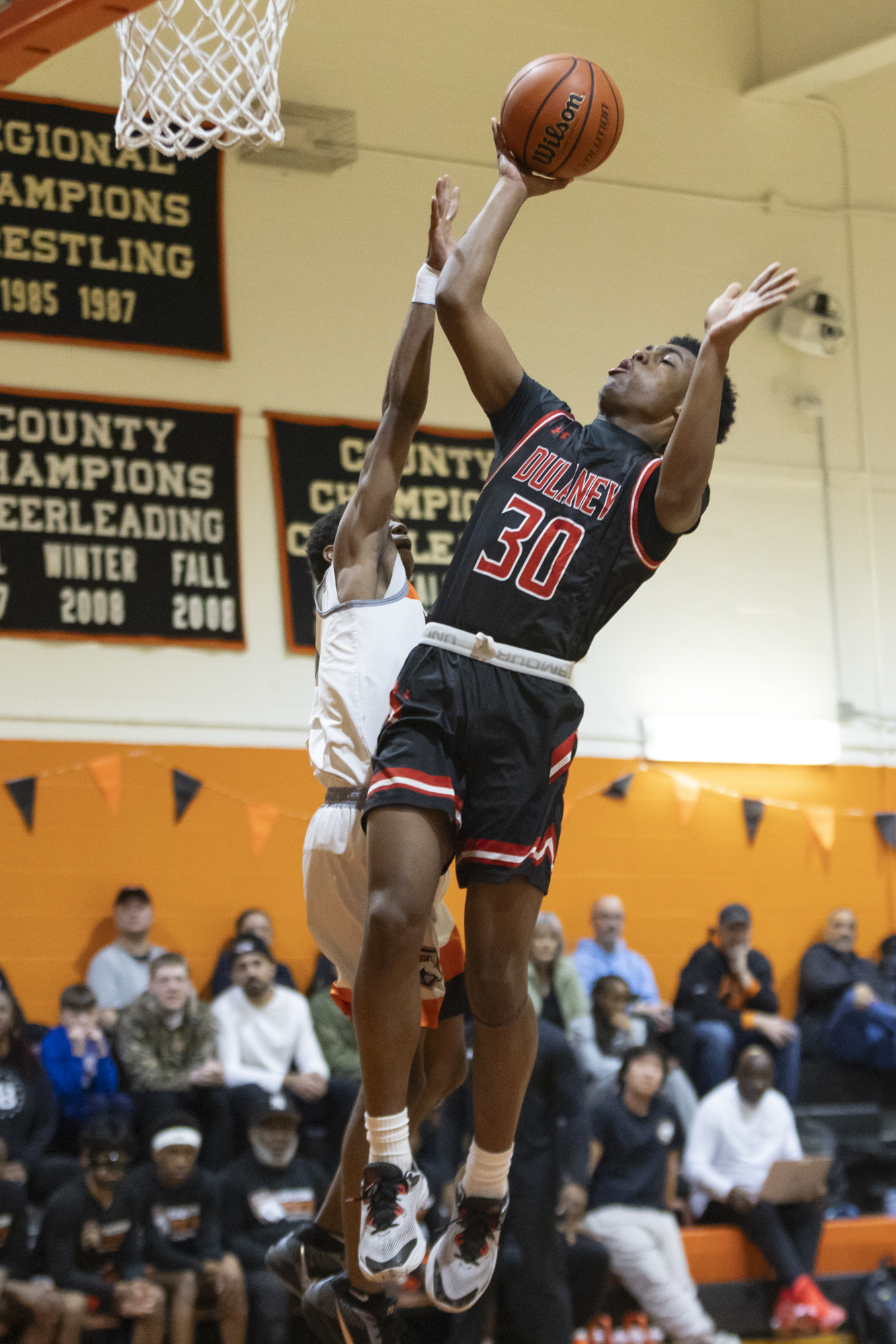 Dulaney’s Devin Coward takes off for a contested shot as...
