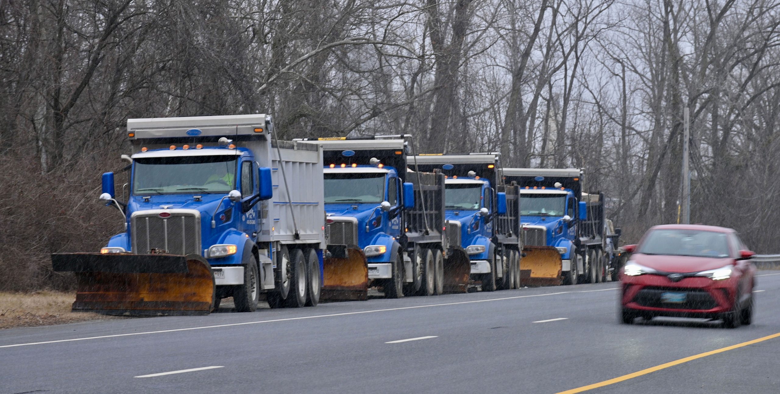 A row of snow plows stand ready for action along...