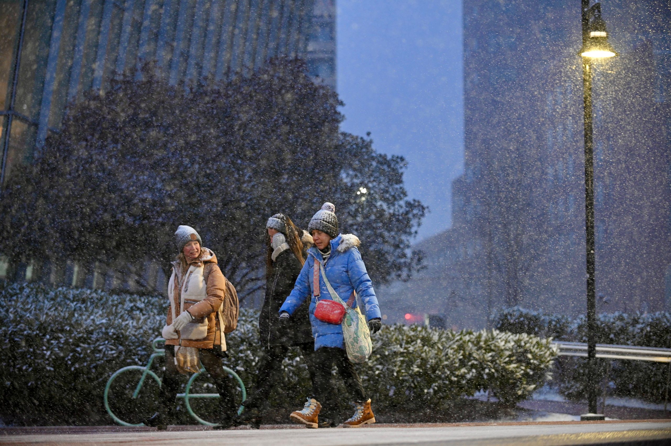 People stroll around the Inner Harbor as the snow falls...