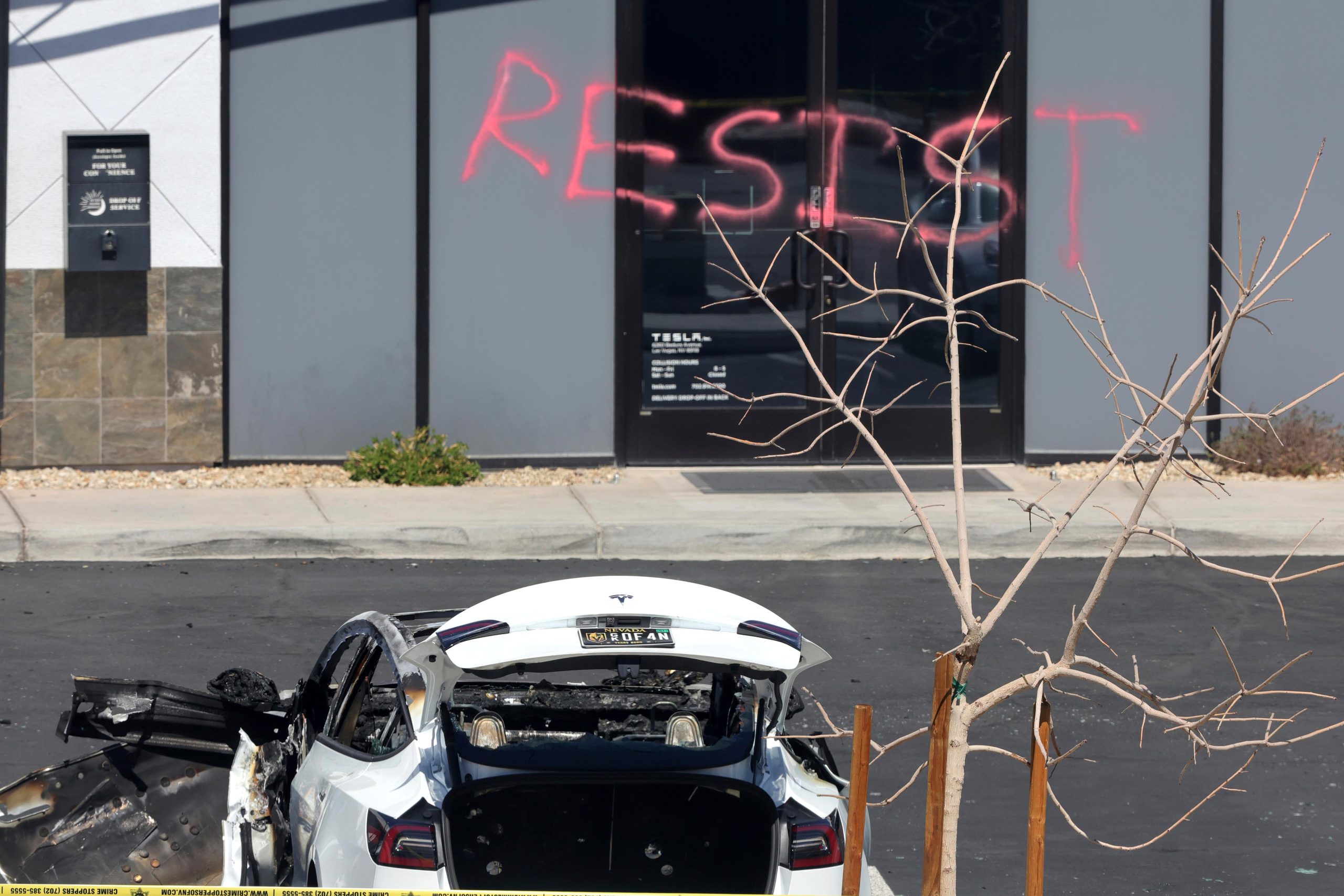 A burned Tesla vehicle is shown at a Tesla collision...