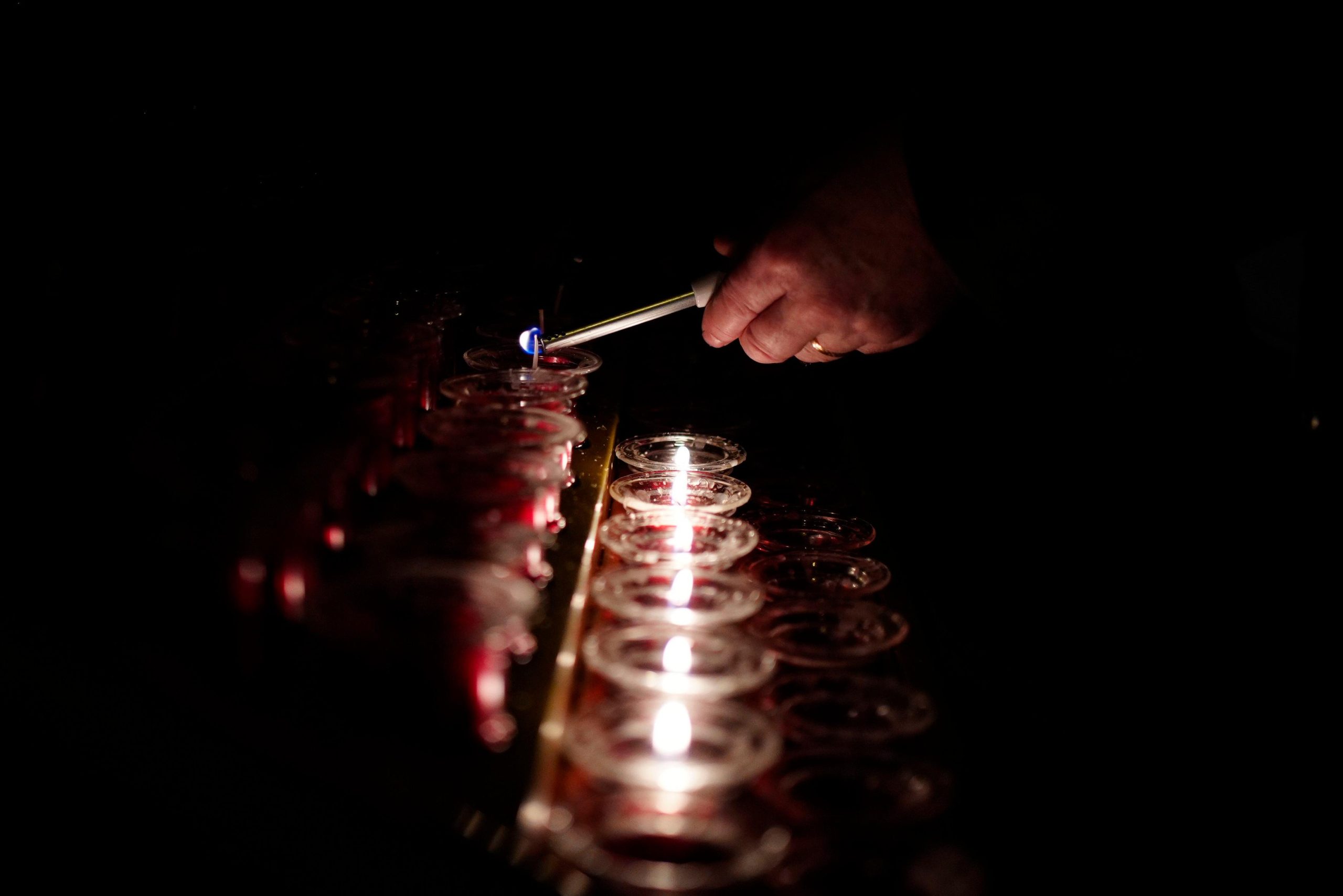 A person lights a candle at Liverpool Metropolitan Cathedral following...