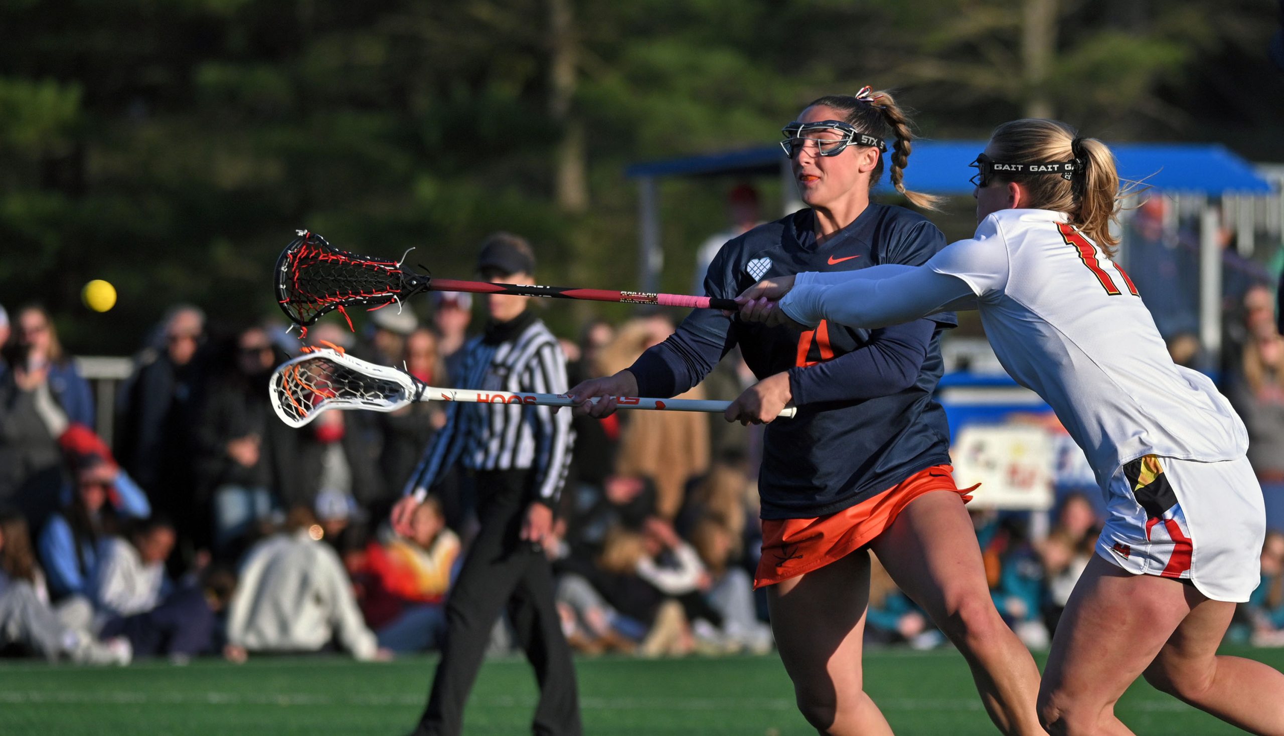 Virginia’s Jenna Dinardo, left, shoots past Maryland’s Maddy Sterling, right,...