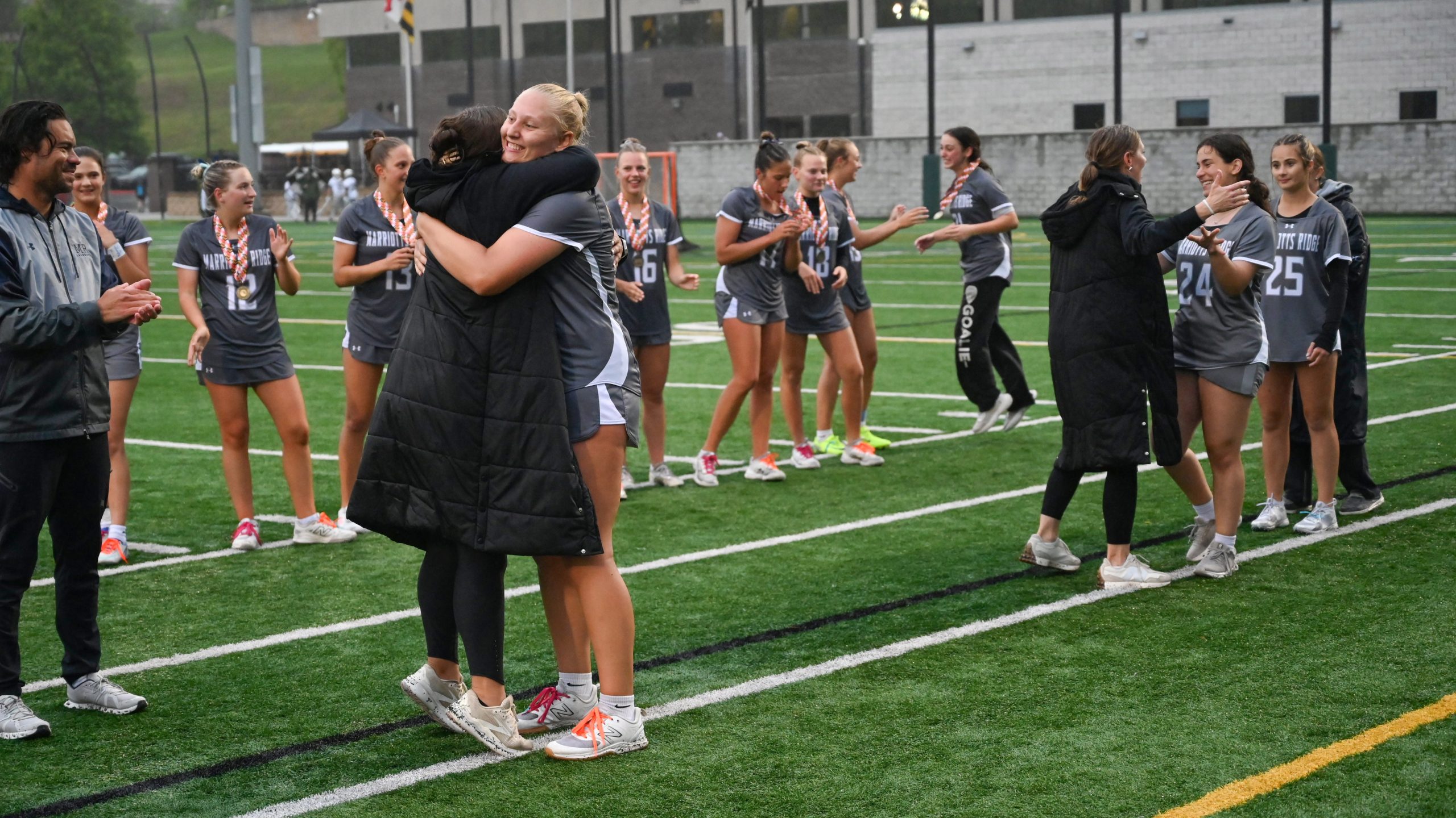 Marriotts Ridge players embrace their coaches as they accept their...