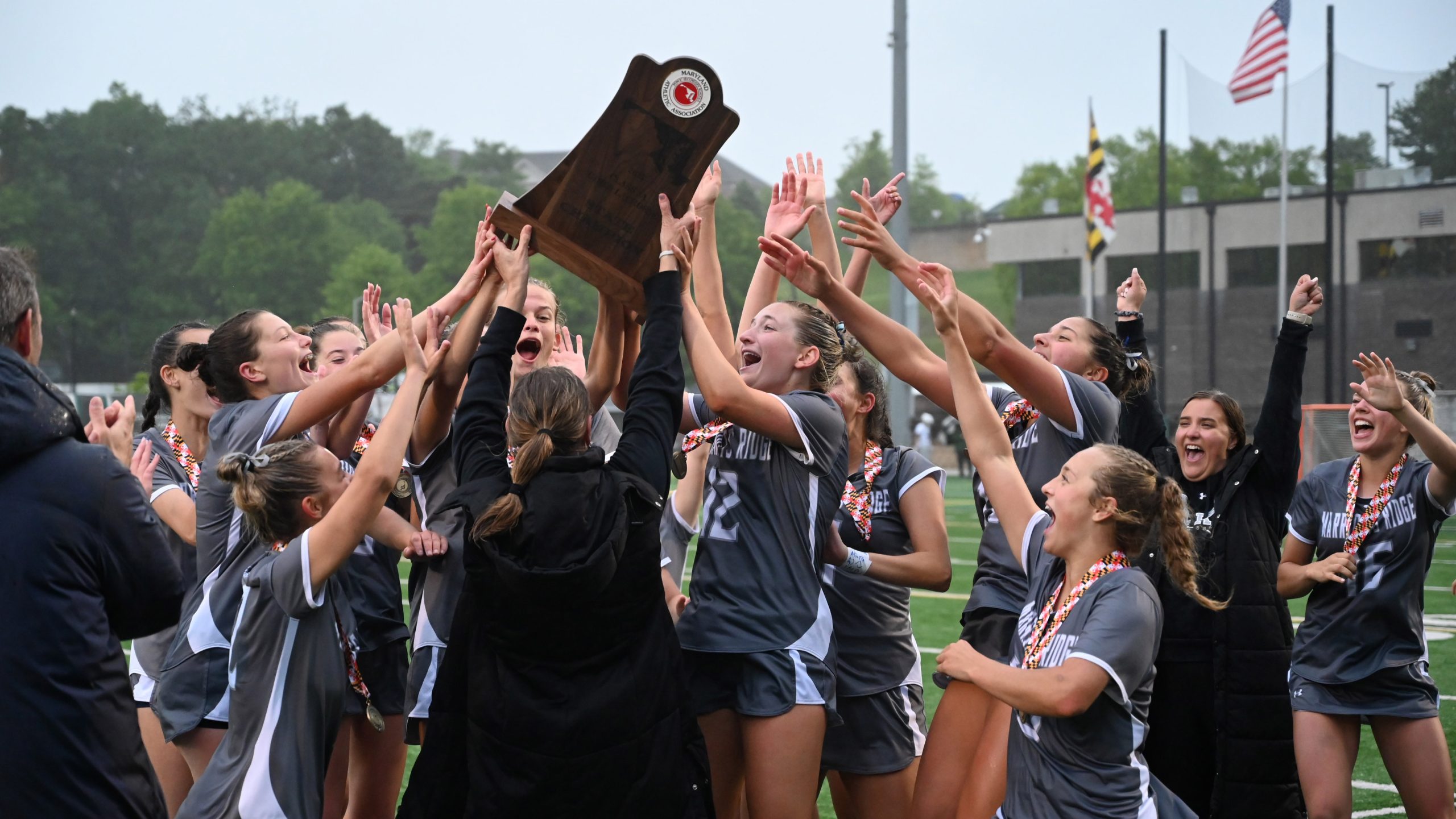 Marriotts Ridge players accept the championship trophy and celebrate their...