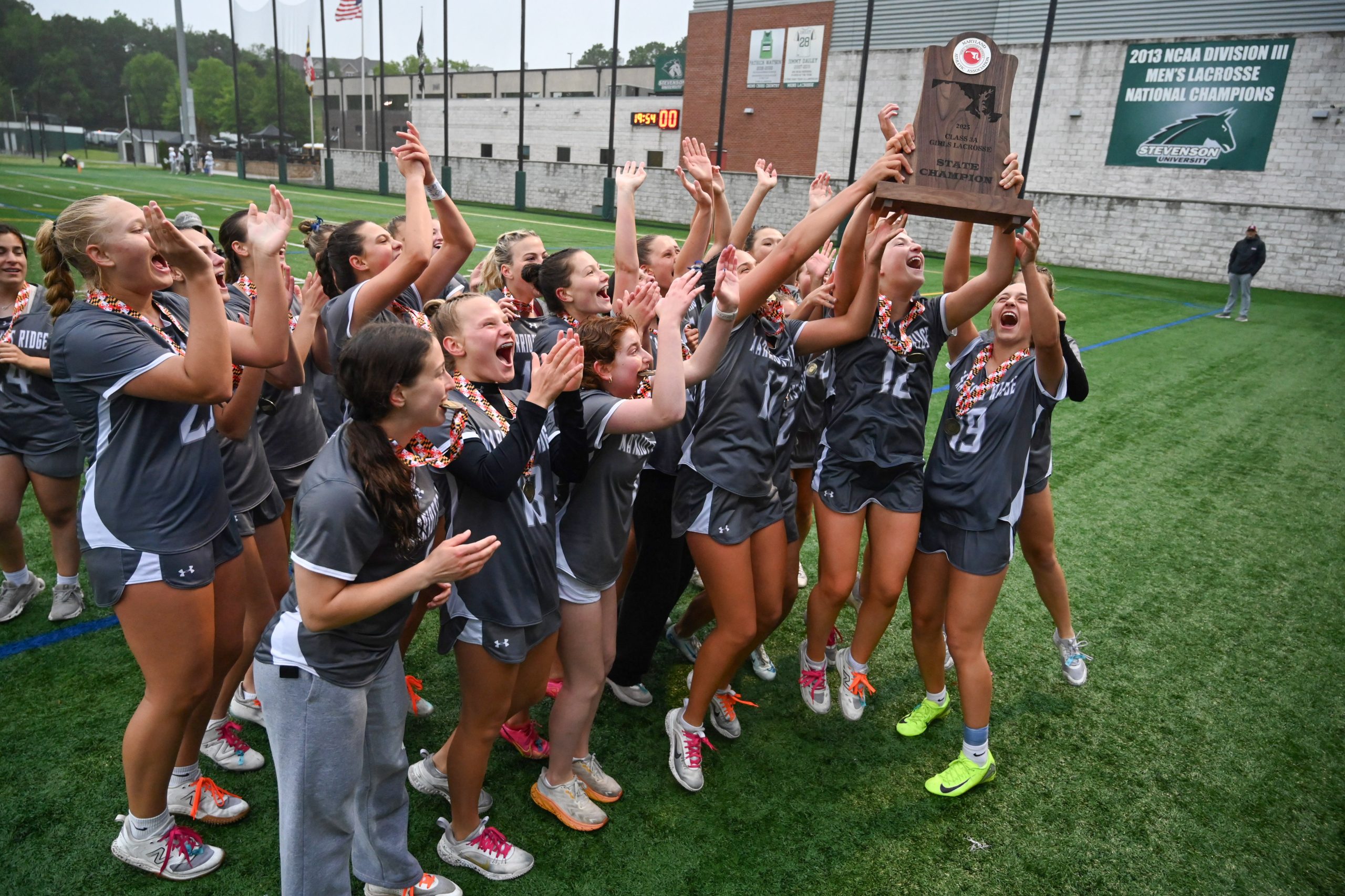 Marriotts Ridge players accept the championship trophy and celebrate their...