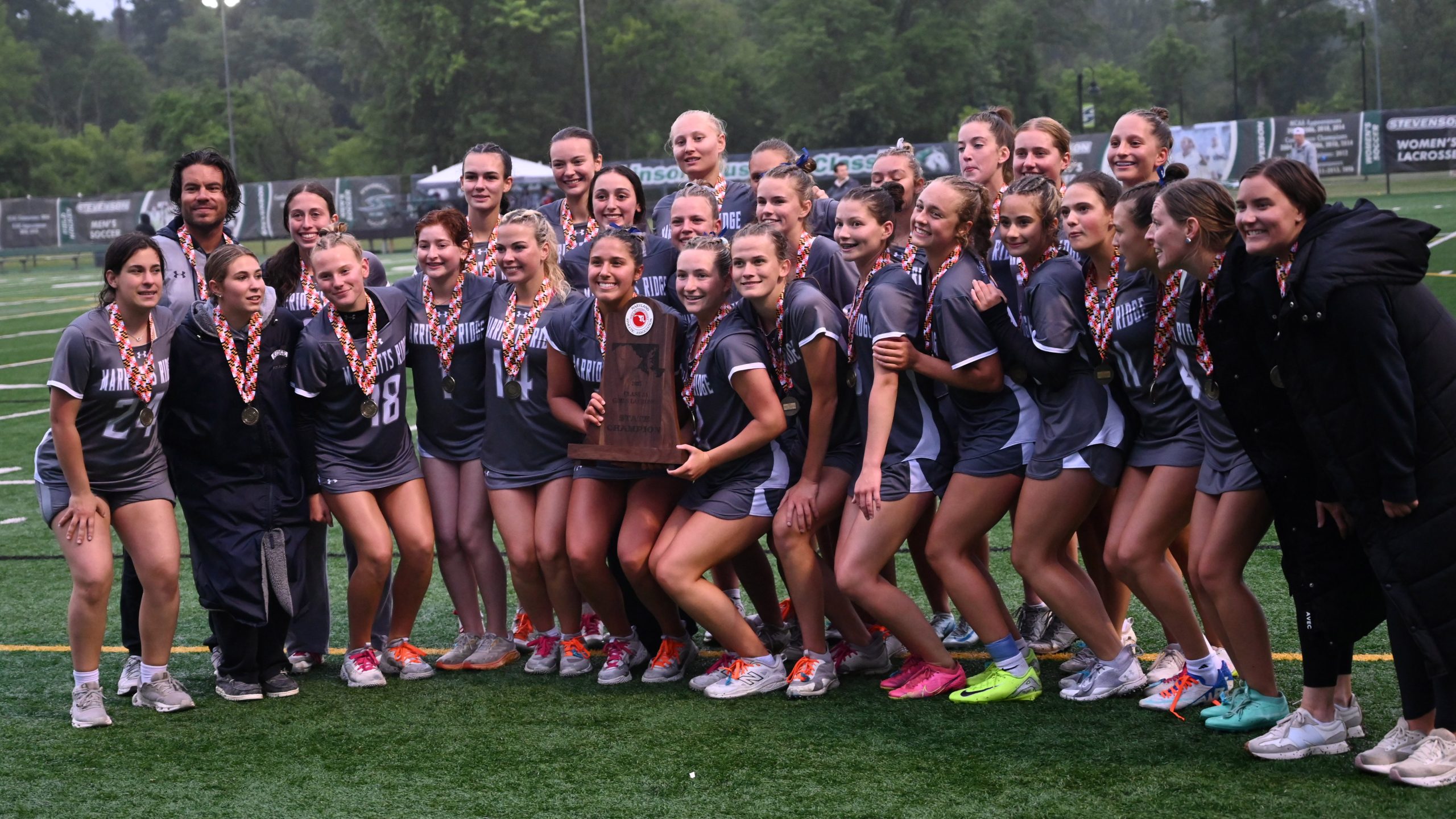 Marriotts Ridge players pose with their championship trophy and celebrate...