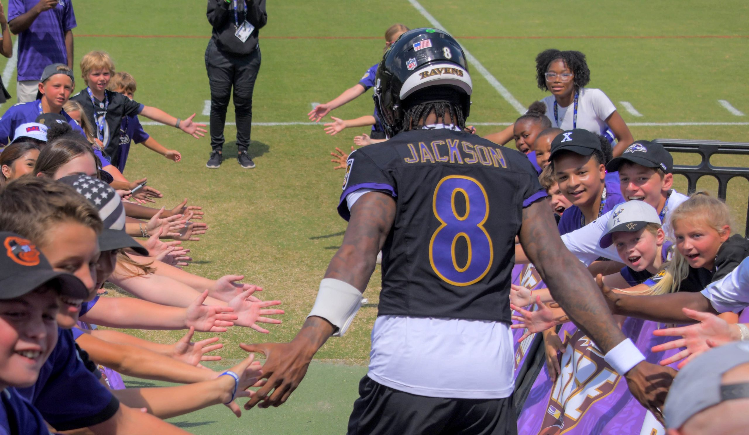 Children greet Baltimore Ravens quarterback Lamar Jackson as he runs...