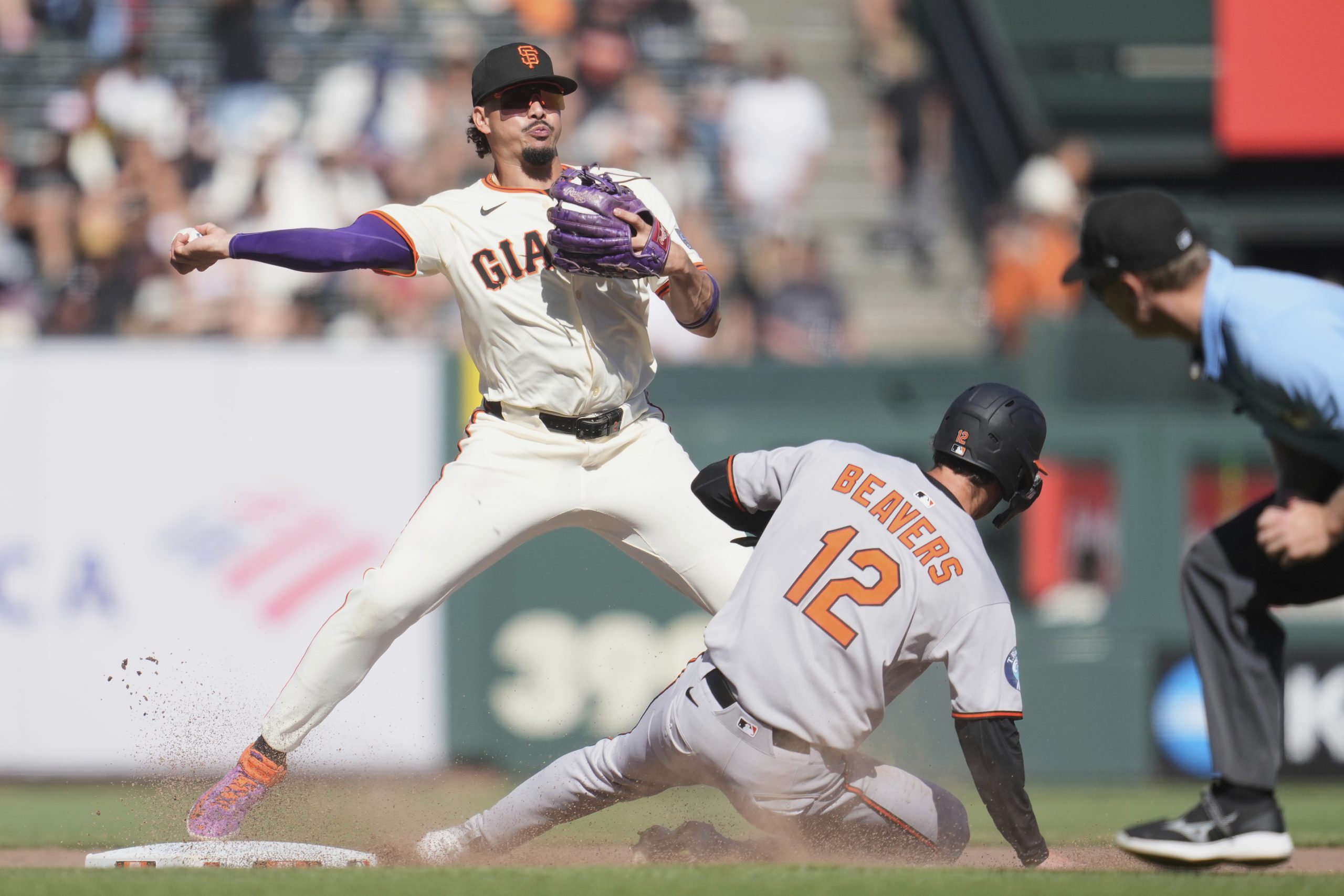 San Francisco Giants shortstop Willy Adames, top, throws to first...