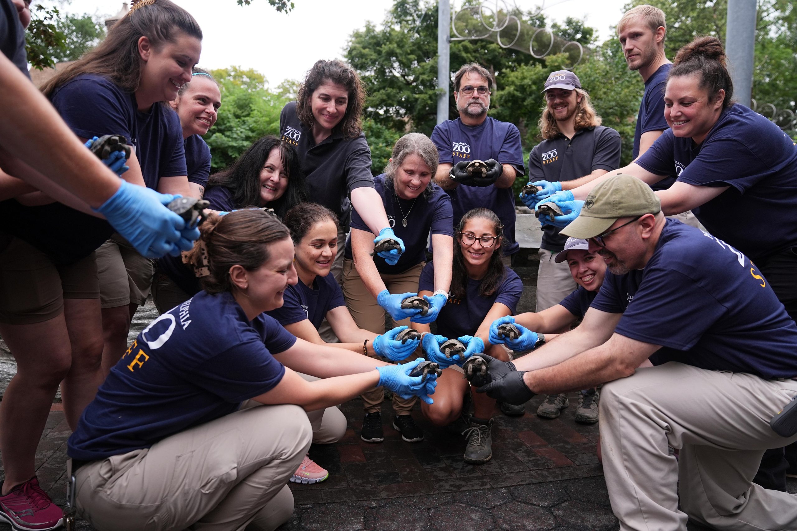 Staff members pose for photographs with 16 critically endangered western...