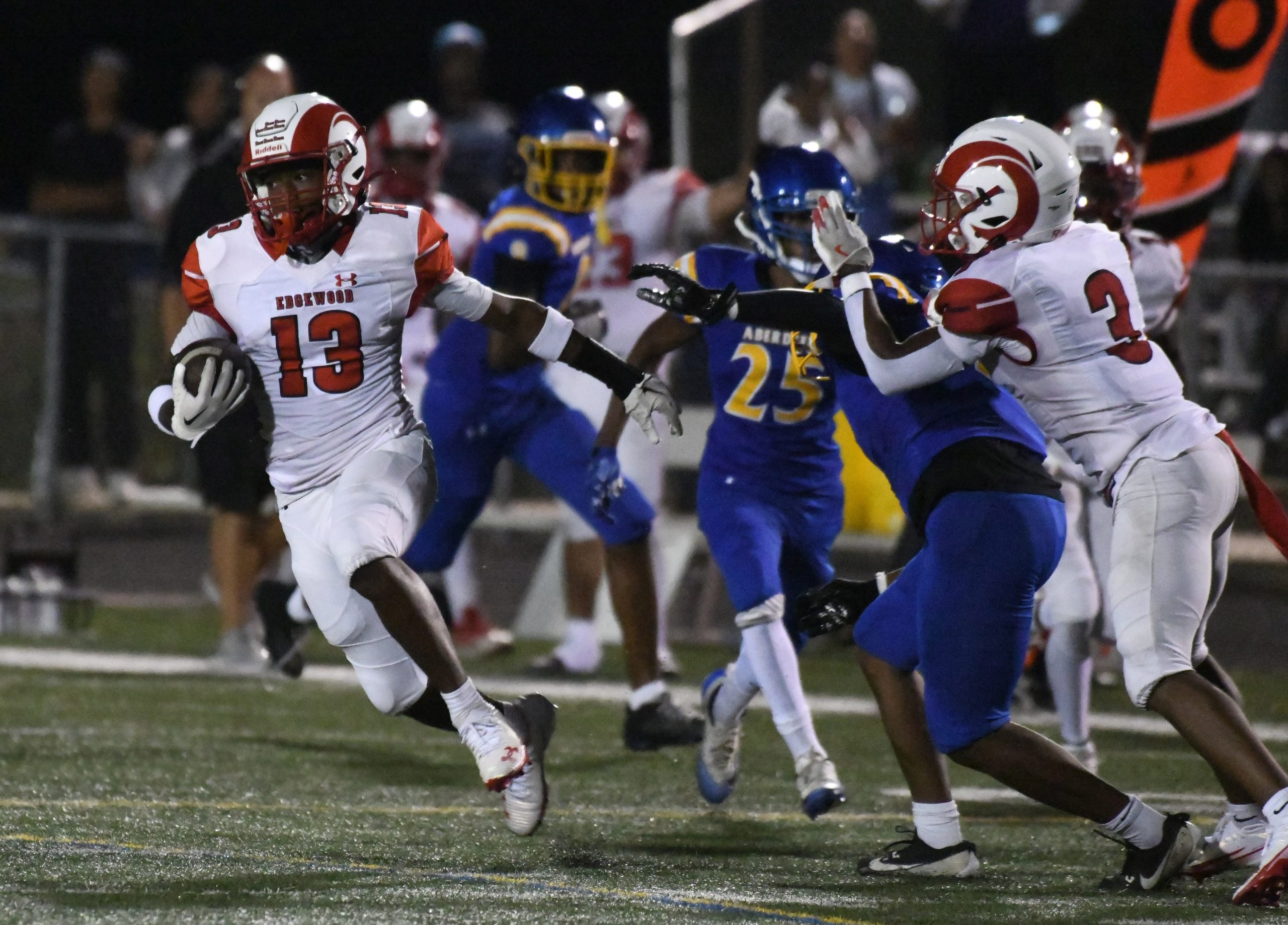 Edgewood Shamari Whitmore tries to avoid Aberdeen tacklers as he...