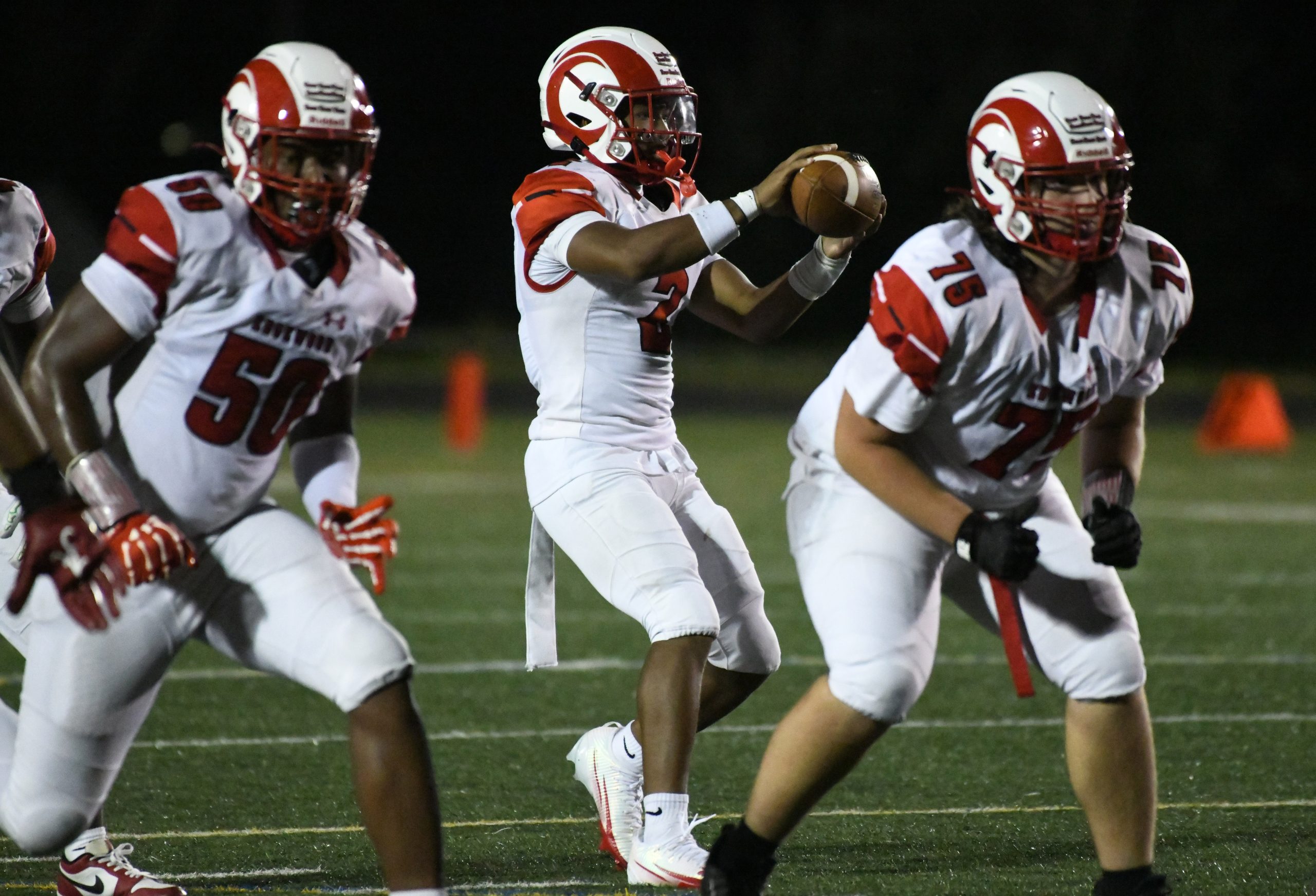 Edgewood's Mike Robinson handles a shotgun snap with linemen Oladipo...