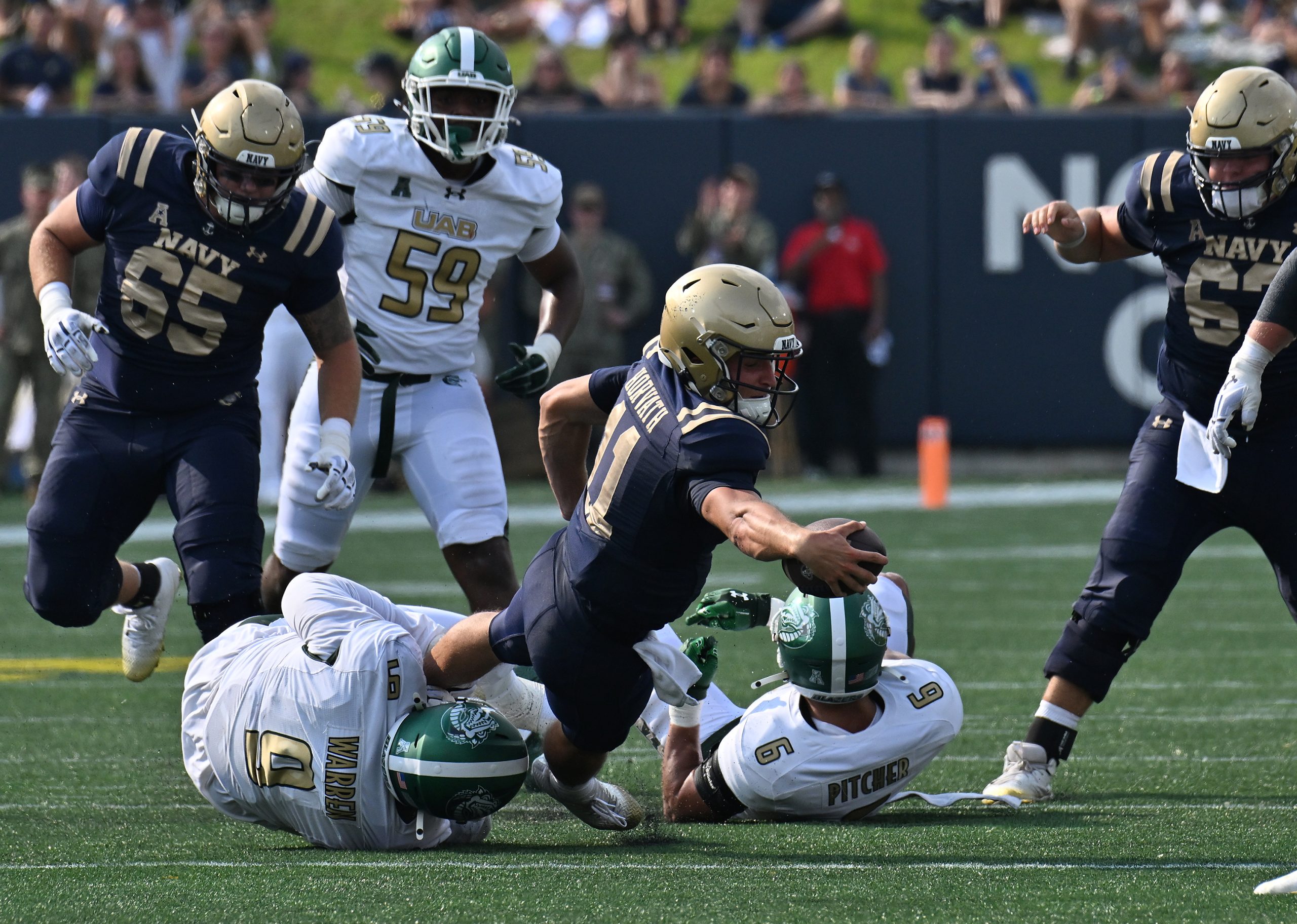 Navy quarterback Blake Horvath stretches for a first down on...