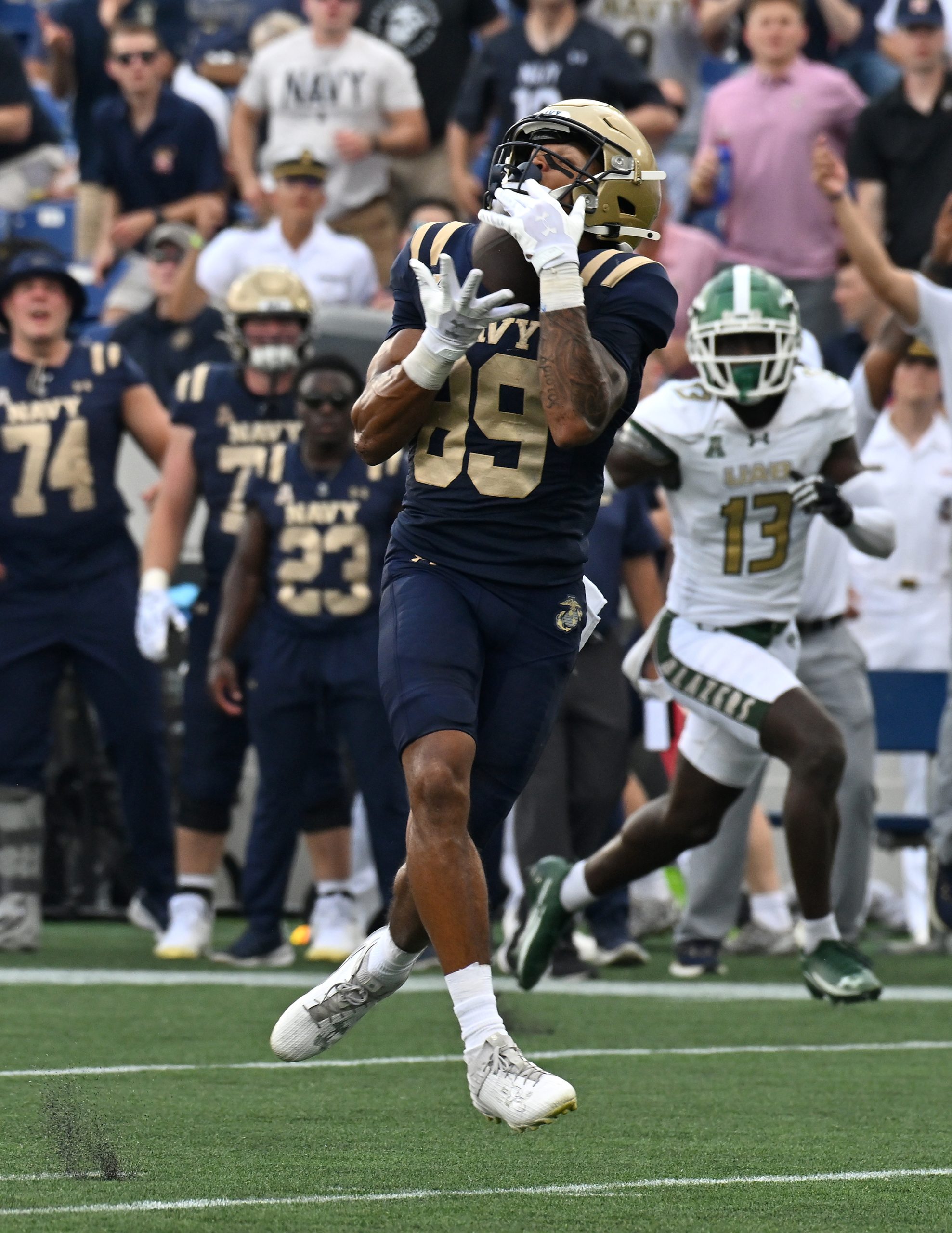 Navy’s Luke Hutchison catches a pass from Blake Horvath and...