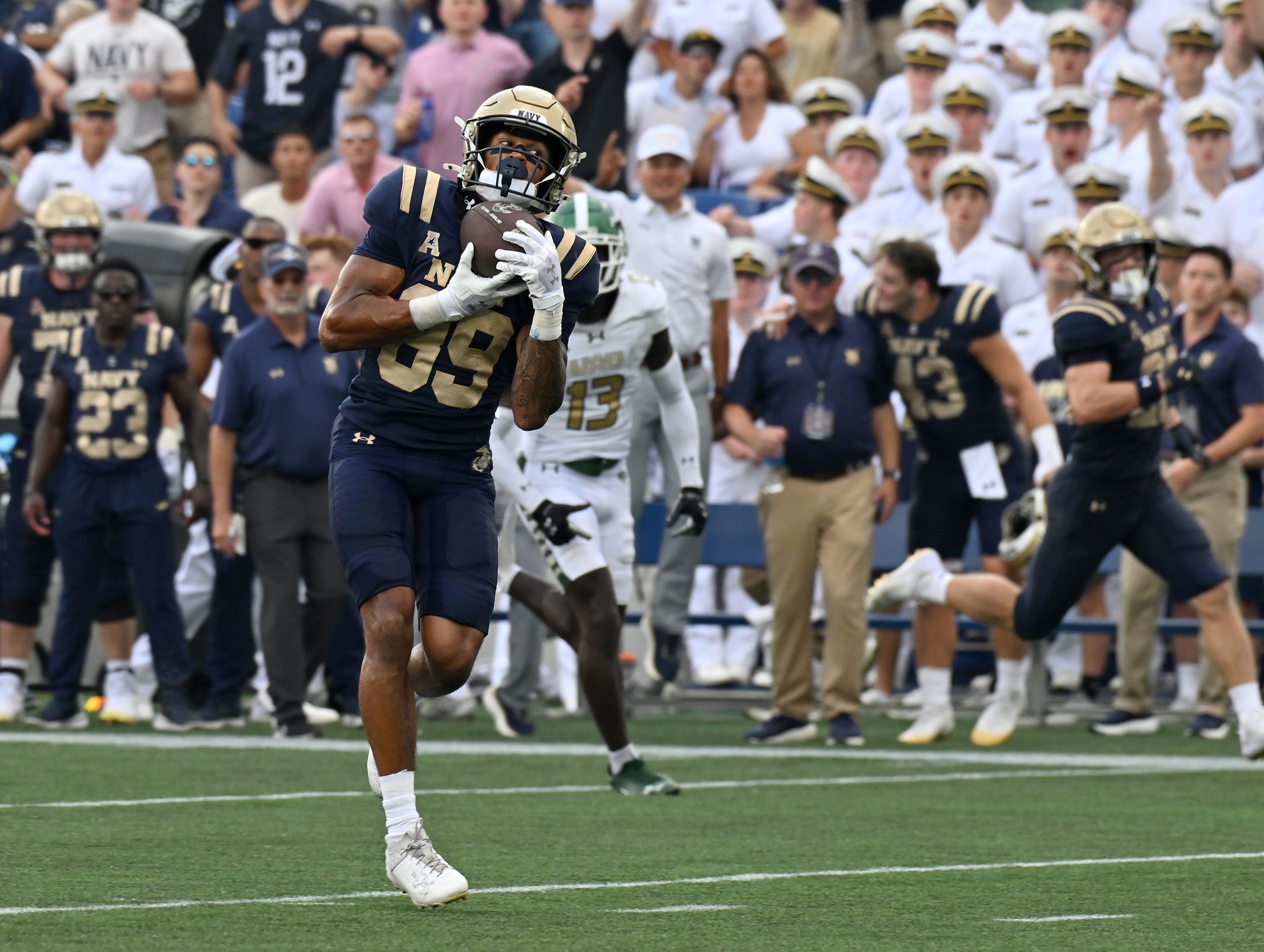 Navy’s Luke Hutchison catches a pass from Blake Horvath and...
