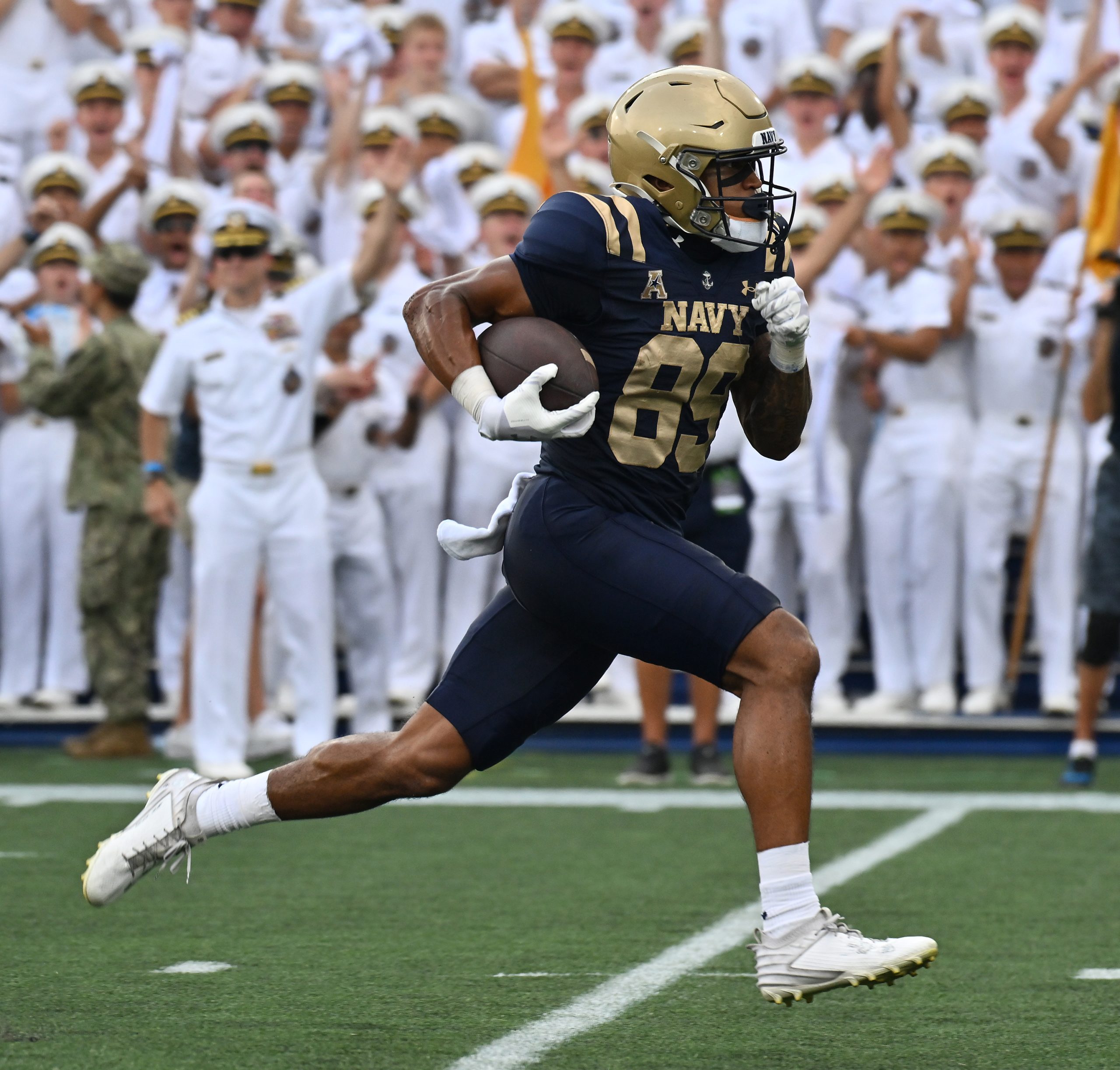 Navy’s Luke Hutchison catches a pass from Blake Horvath and...