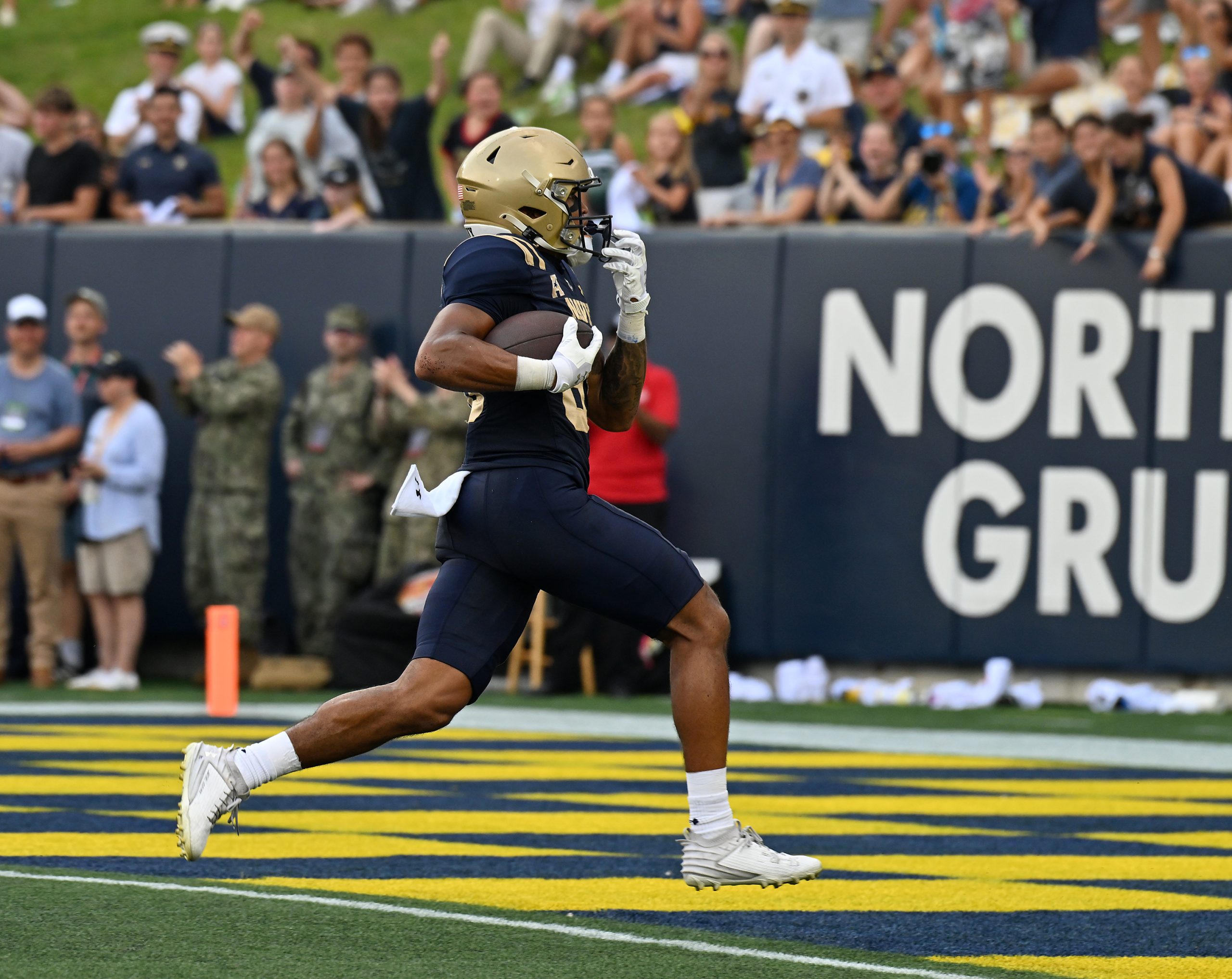 Navy’s Luke Hutchison catches a pass from Blake Horvath and...