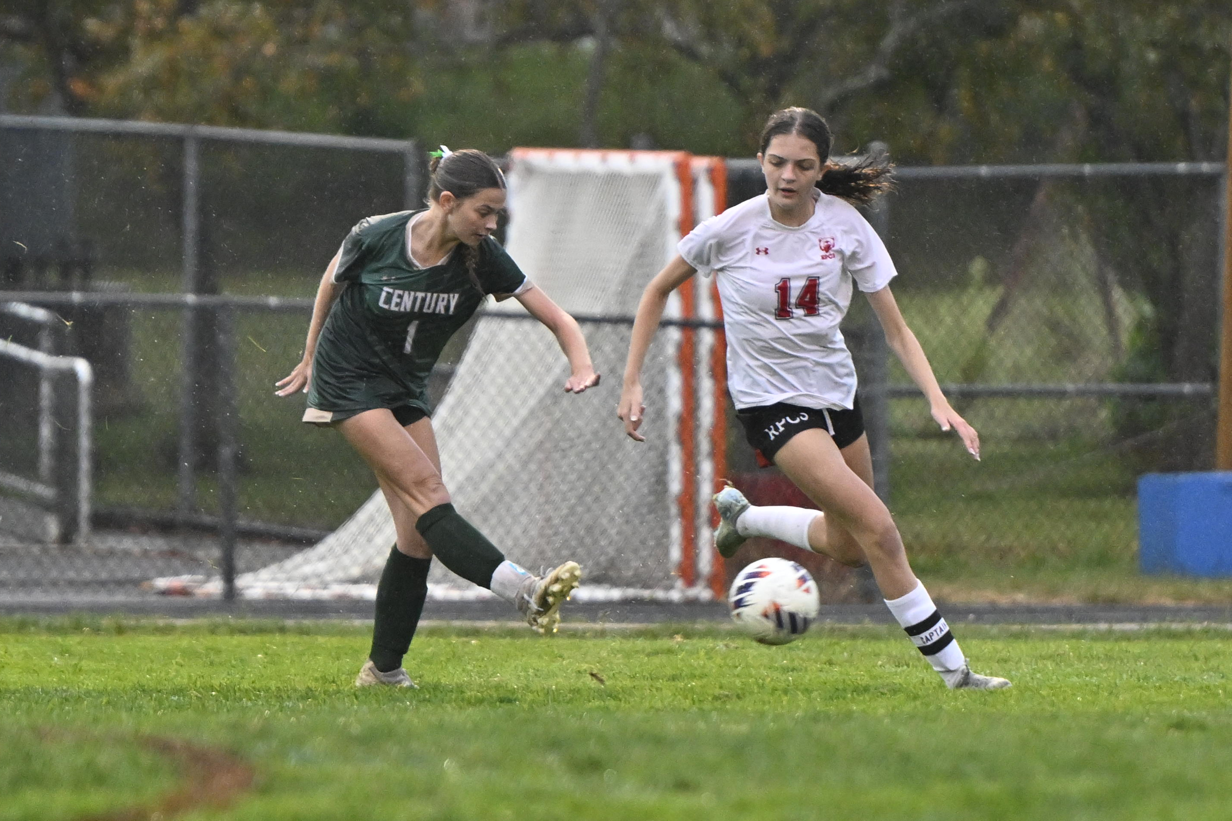 Tegan James kicks the ball in front of Roland Park's...