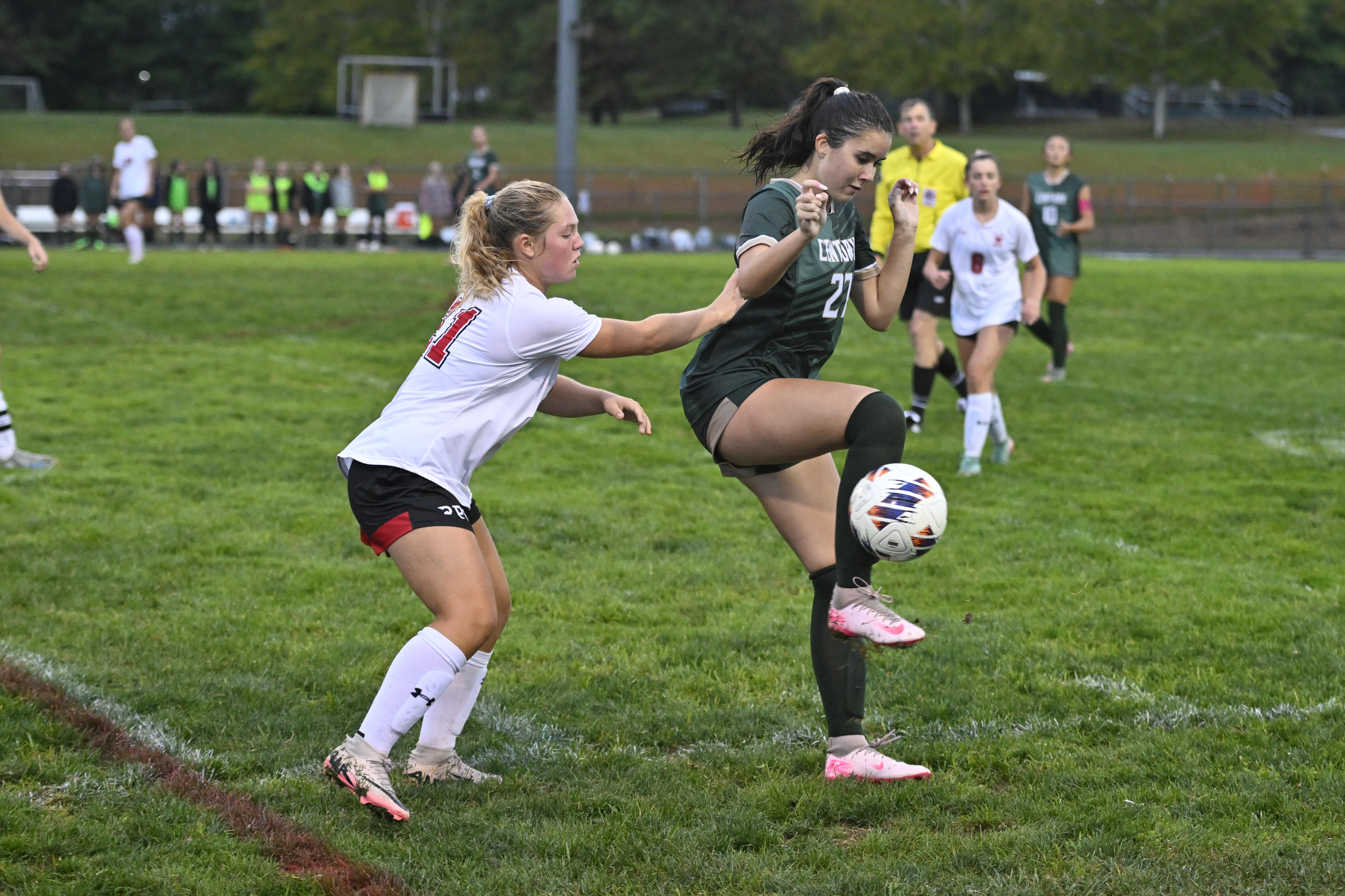 Payton O'Kelley kicks the ball as Roland Park's Callista Connor...