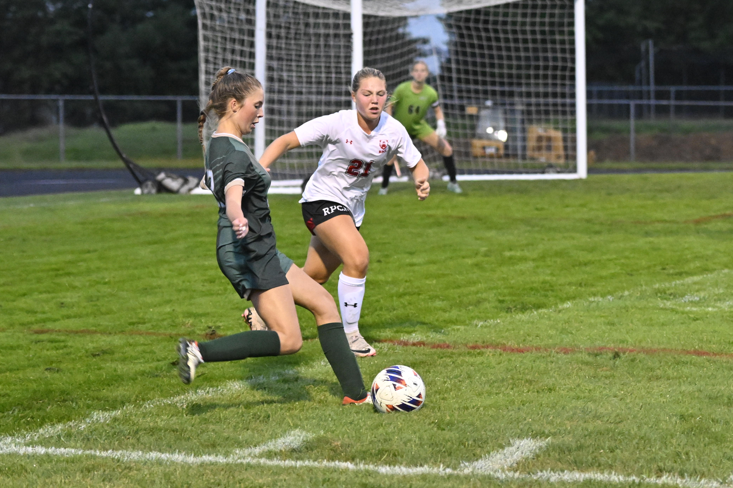 Khloe Schaeffer centers the ball as Roland Park's isabel Insley...