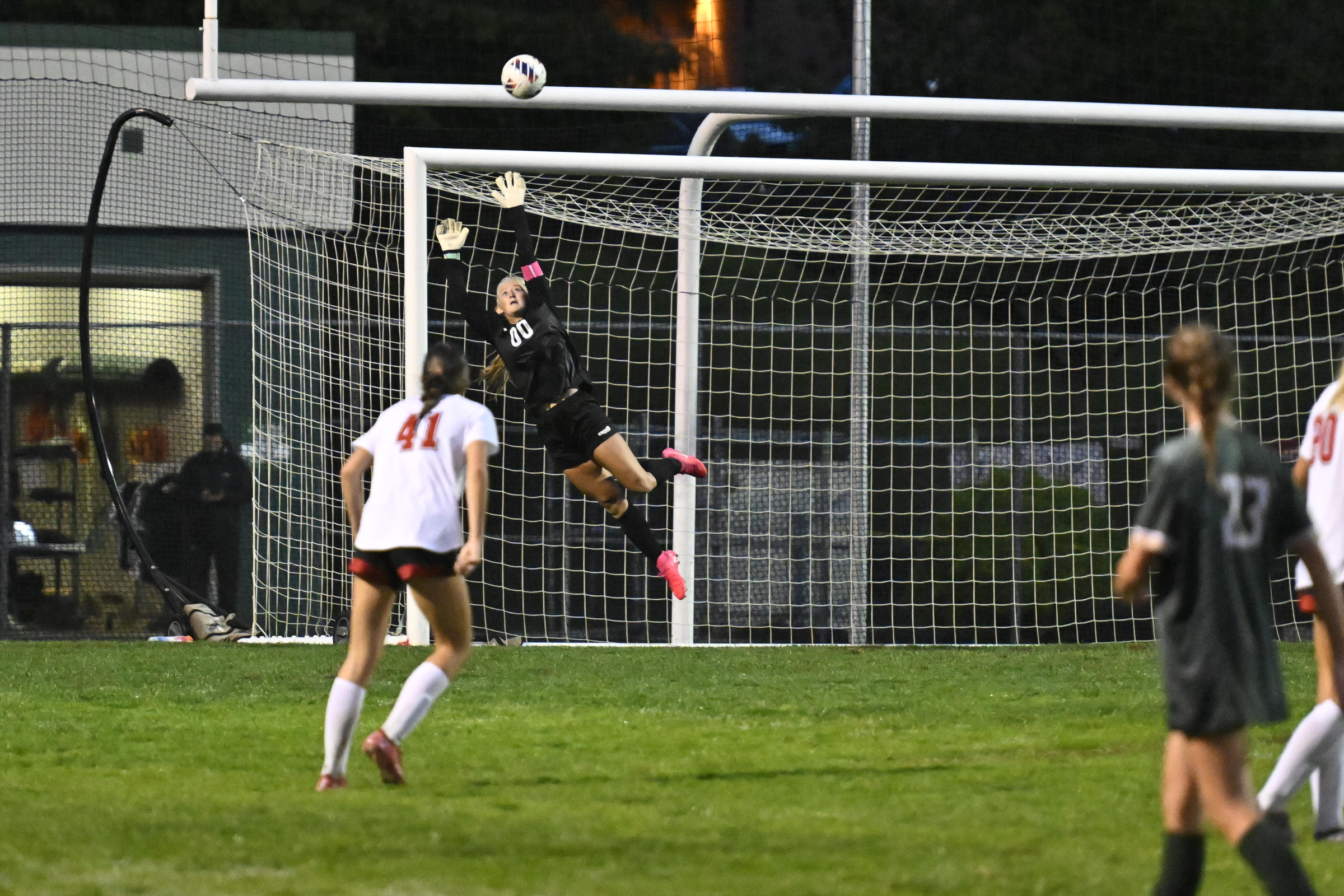 Century goalie Megan Taltavull jumps high as a Roland Park...