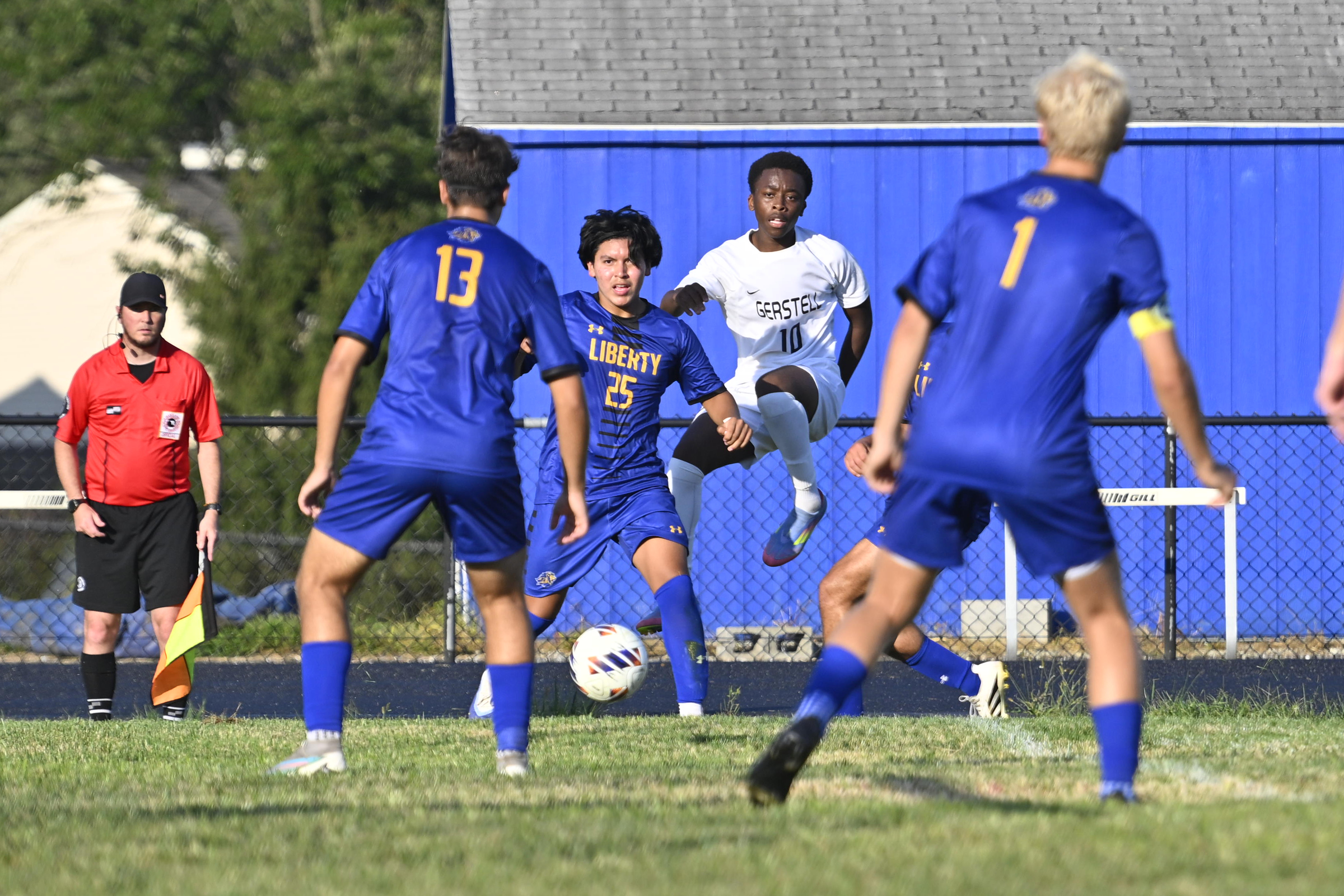 Liberty's William Paucar and Gerstell's Samuel Oluyemi track the ball...