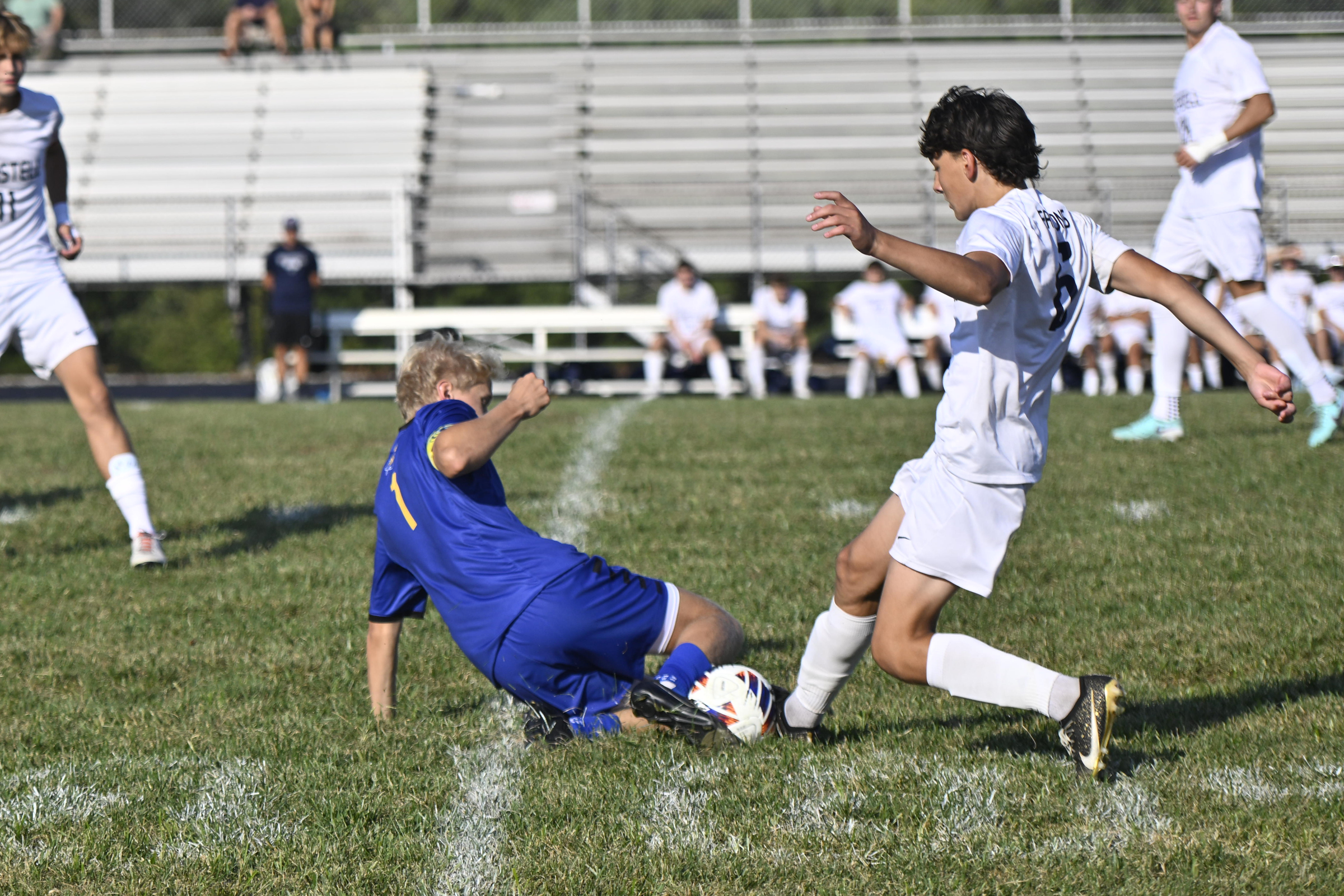 Cooper Geidel makes a slide tackle to take the ball...